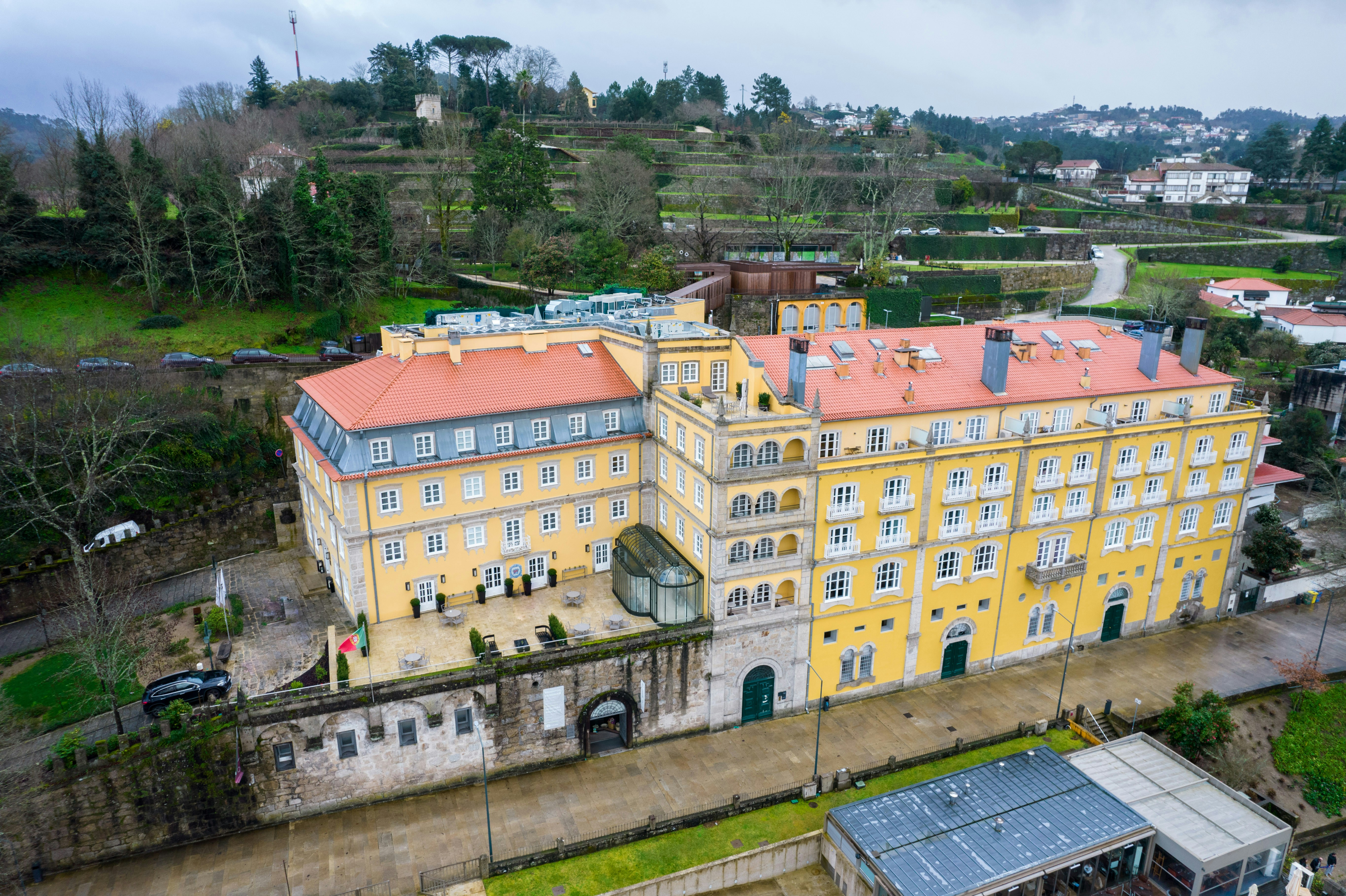 Large yellow building with orange roof on hillside