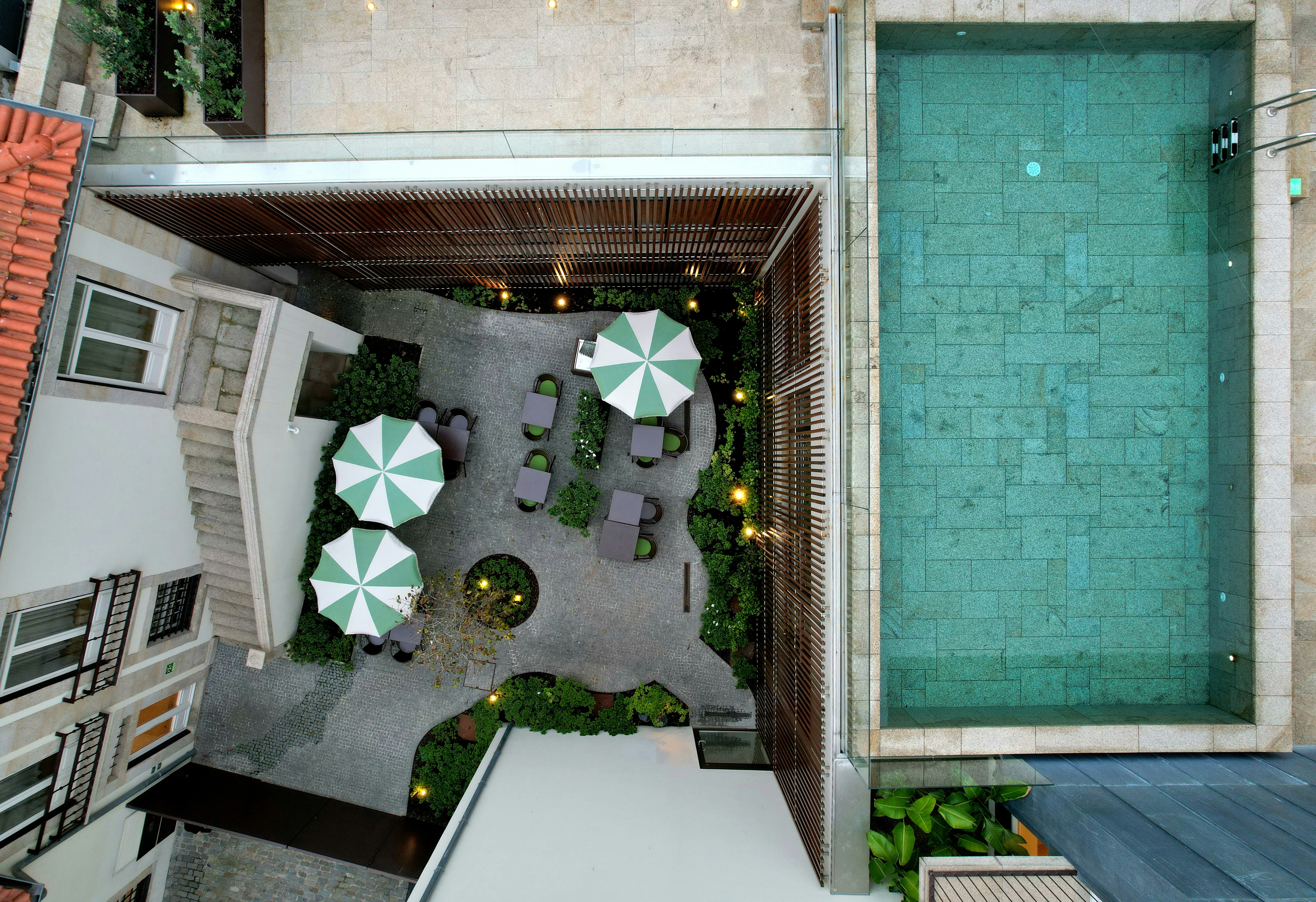 Aerial view of a hotel courtyard with pool and umbrellas