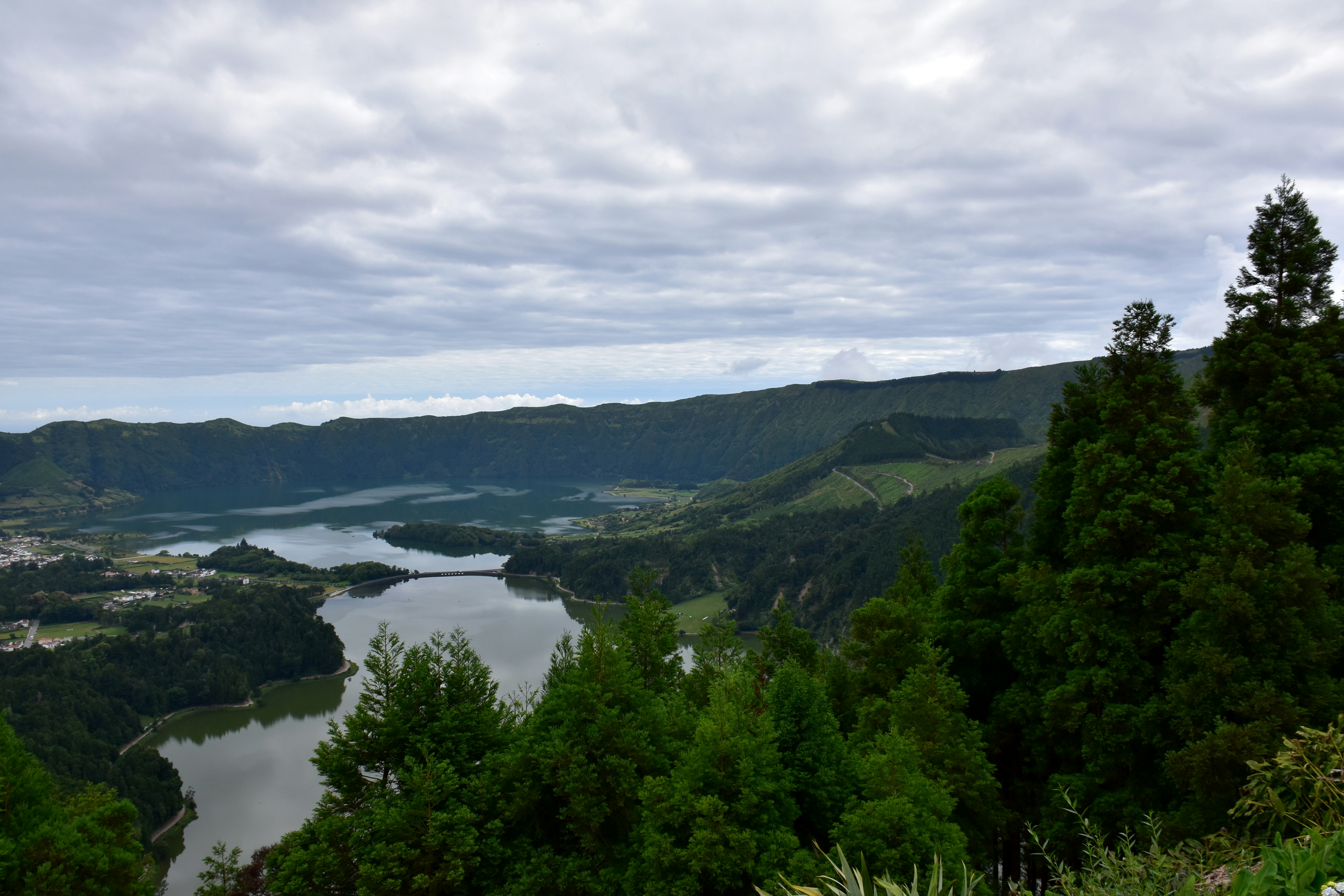 푸른 언덕들이 흐린 하늘 아래 고요한 호수를 둘러싸고 있습니다.