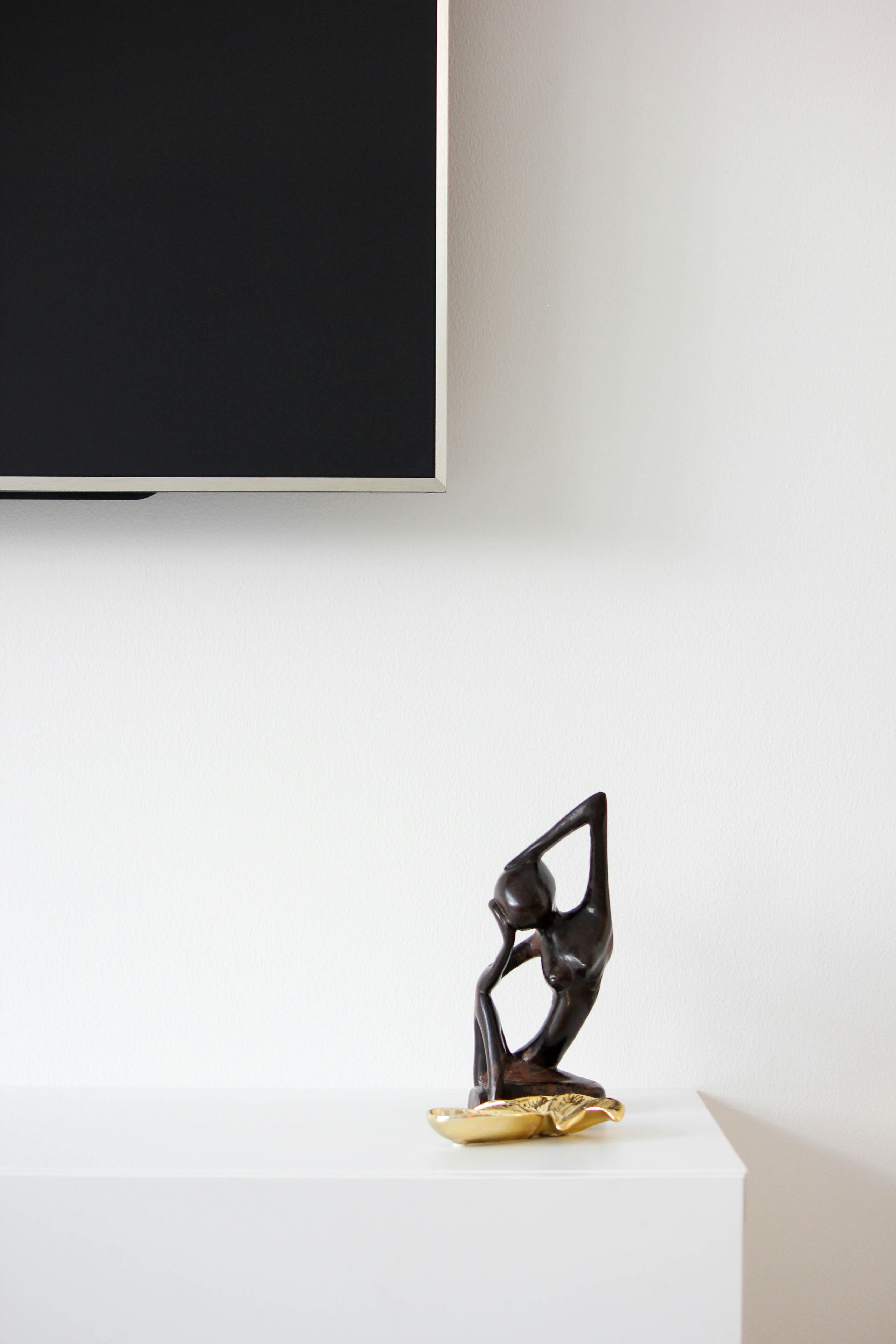 Wooden sculpture of a person on a shelf