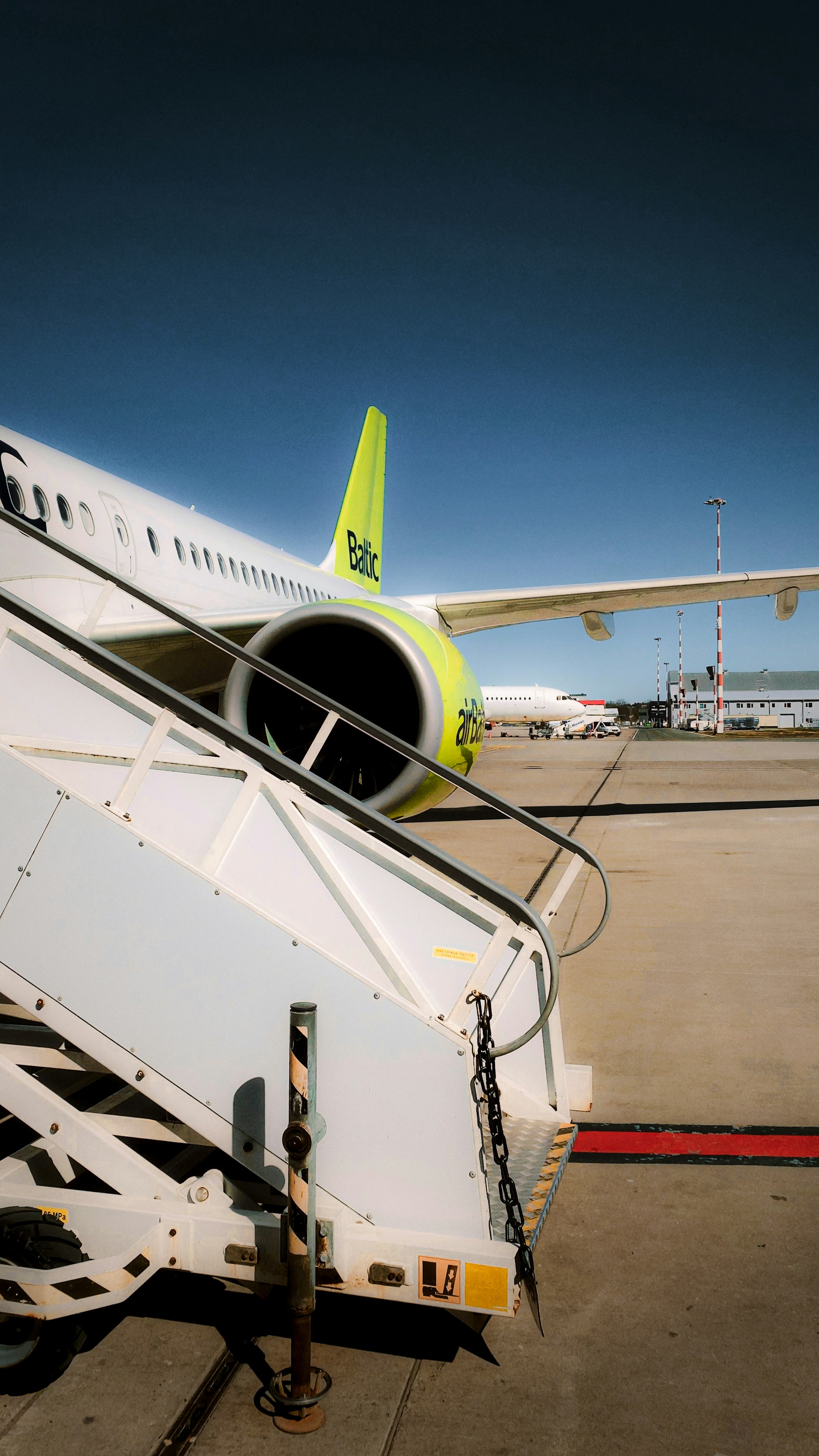 Scale dell'aereo che conducono a un motore a reazione in aeroporto