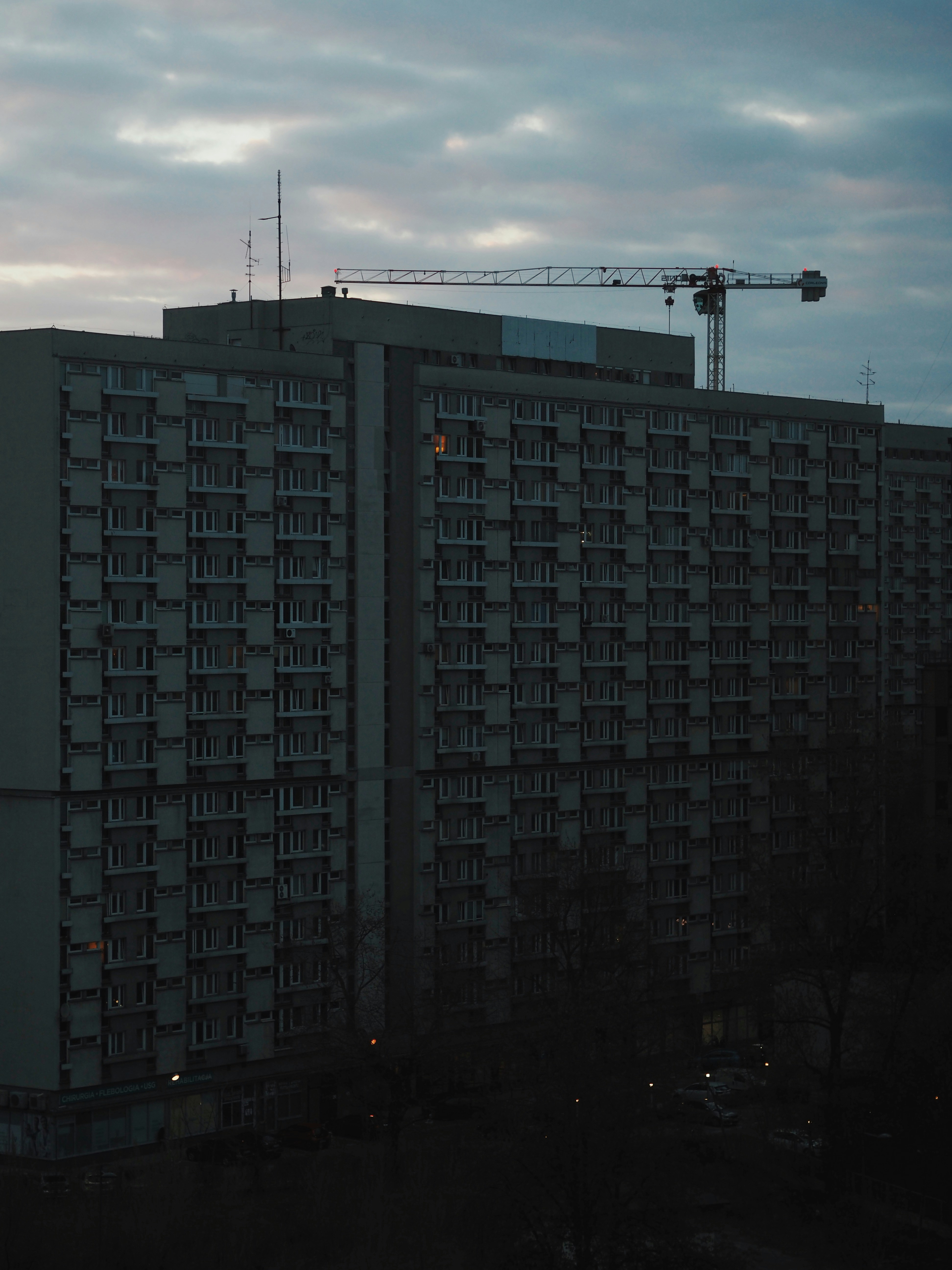 Apartment buildings and construction crane at dusk