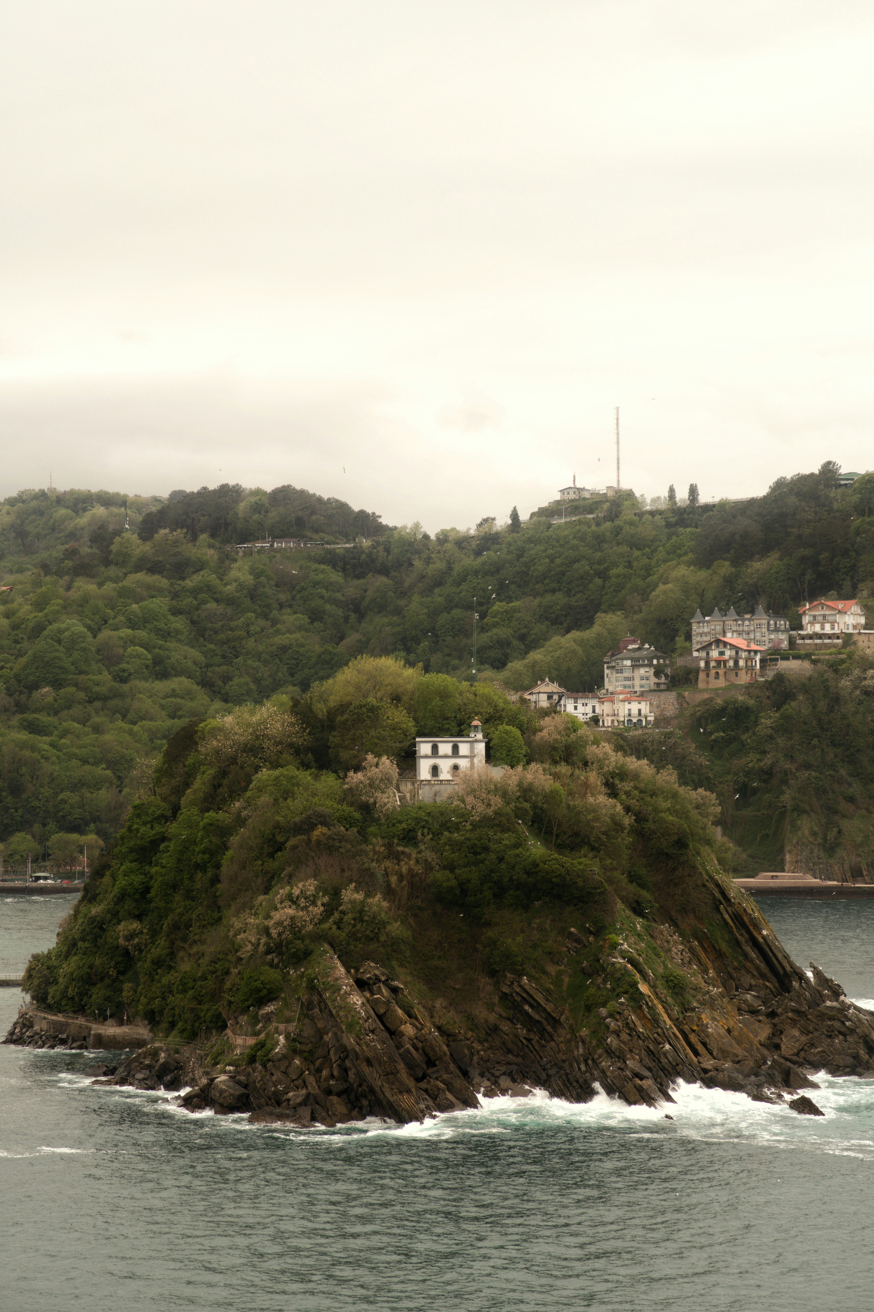 A small island with a white house and trees