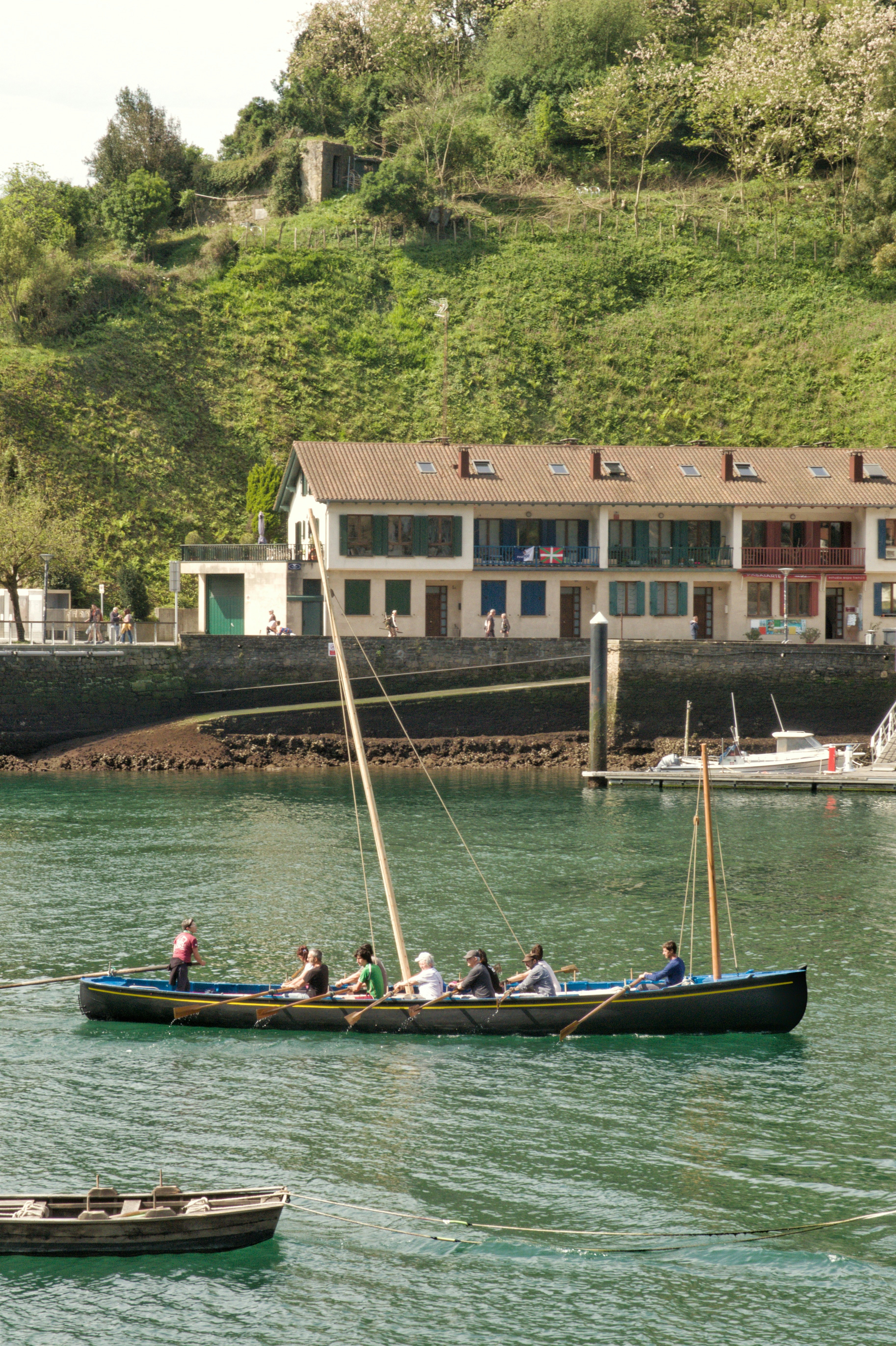 People rowing a traditional boat in a harbor