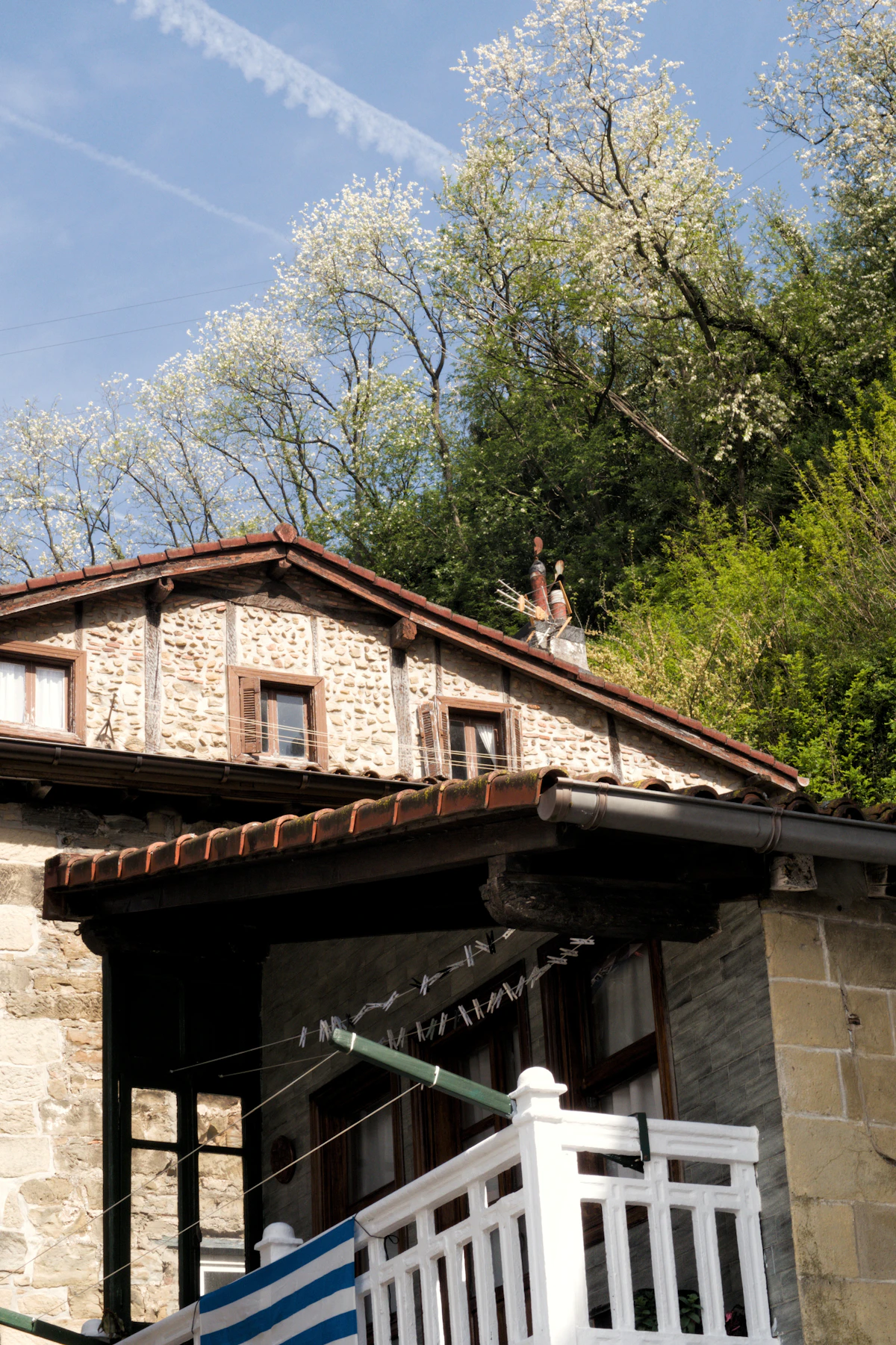 Alero de madera y fachada de piedra de una casona