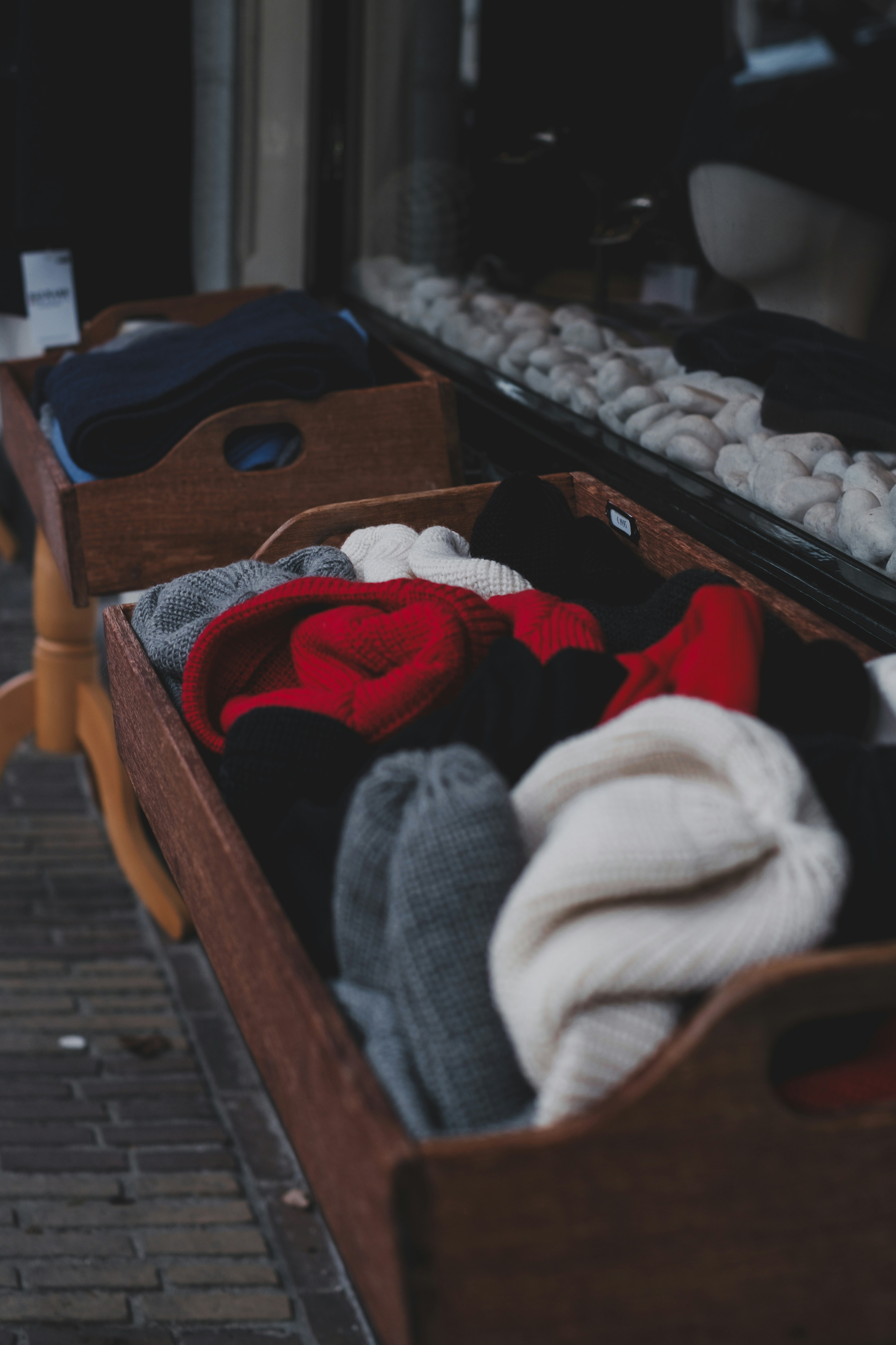 Wooden crates filled with colorful knitted hats and scarves.