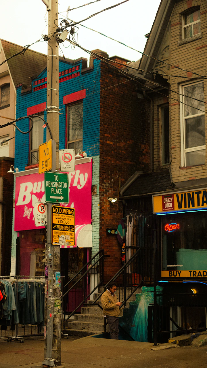 Street view of shops with clothing racks and signs