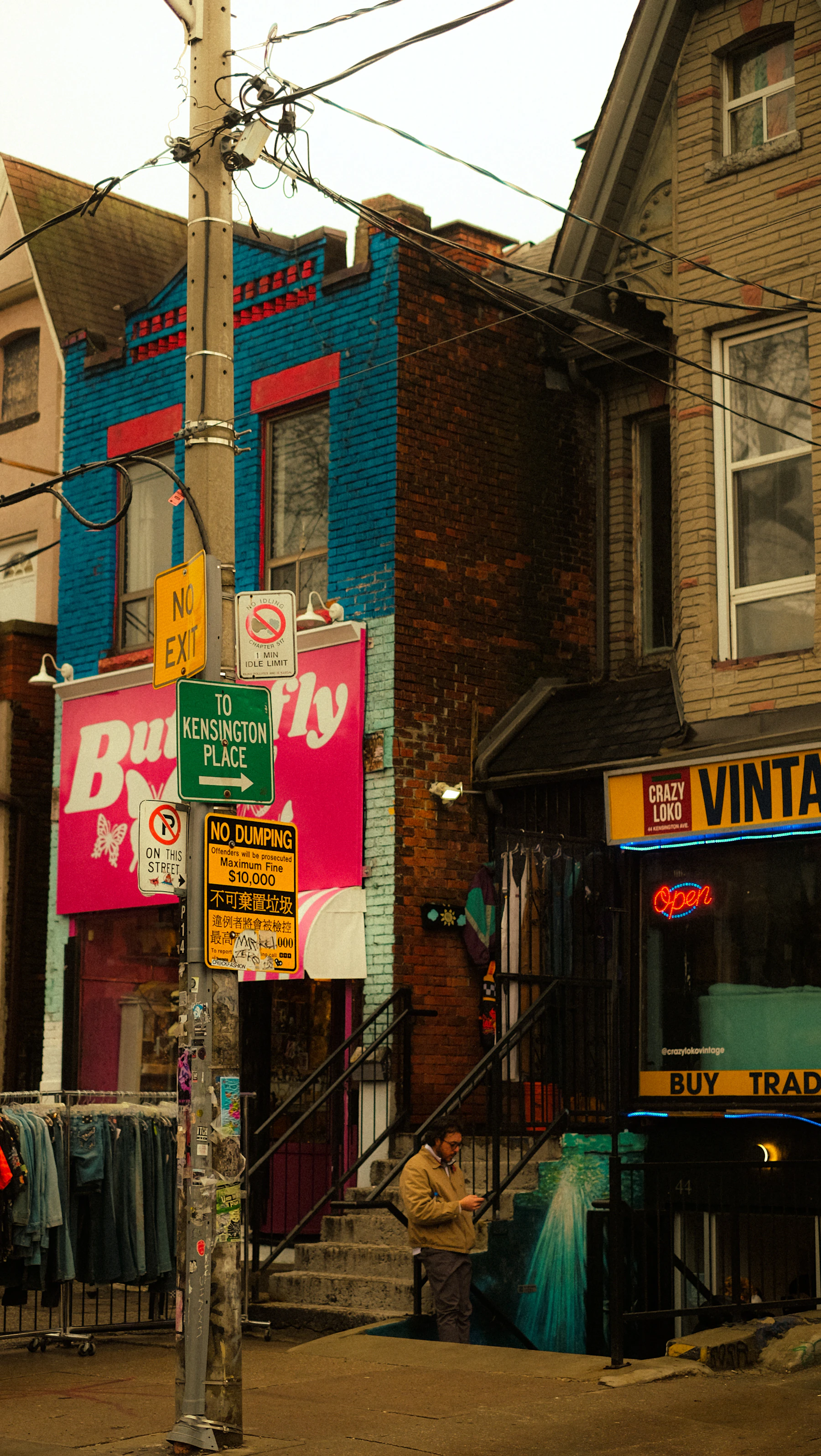 Street view of shops with clothing racks and signs