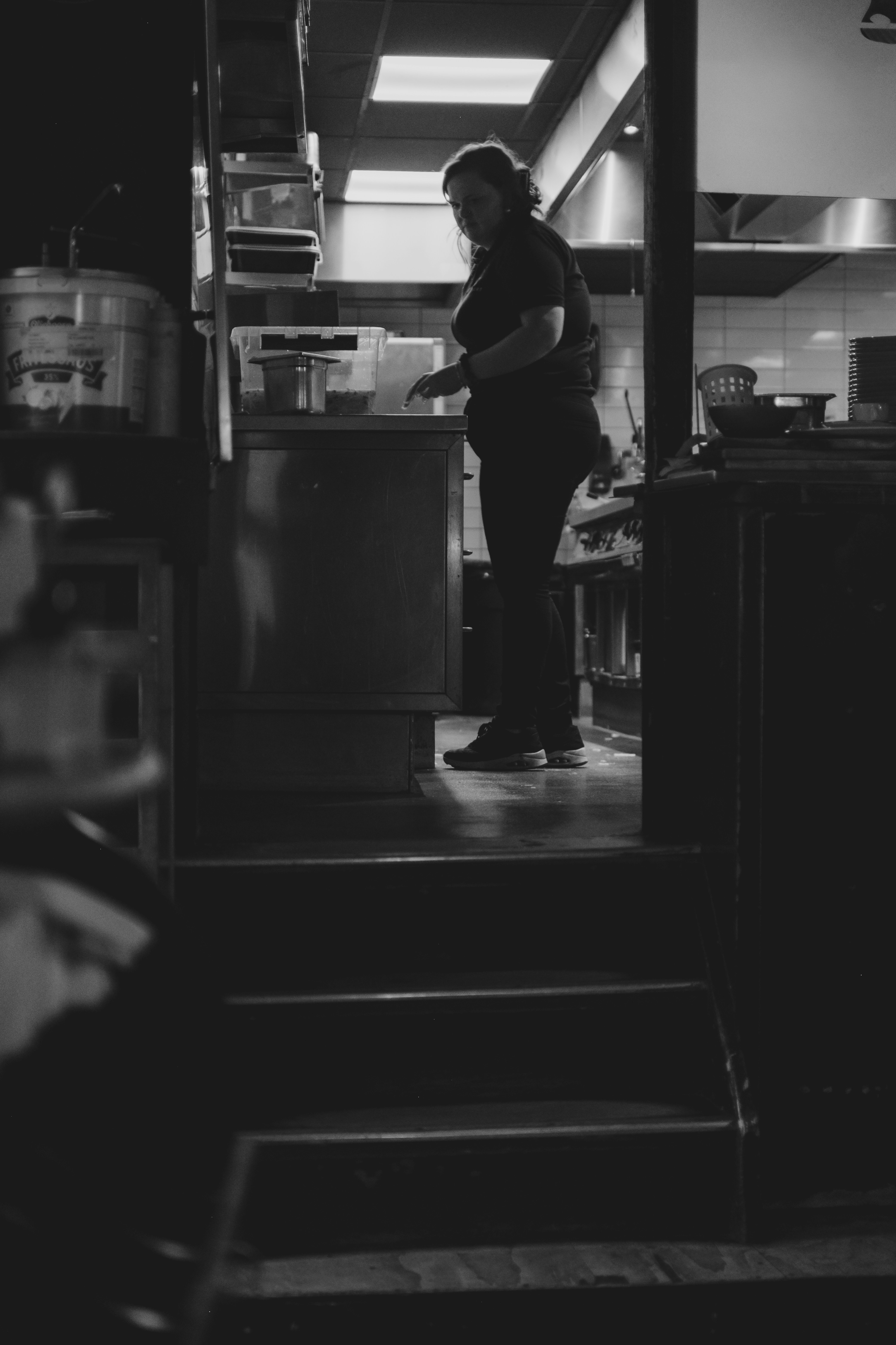 A person works in a dimly lit kitchen.