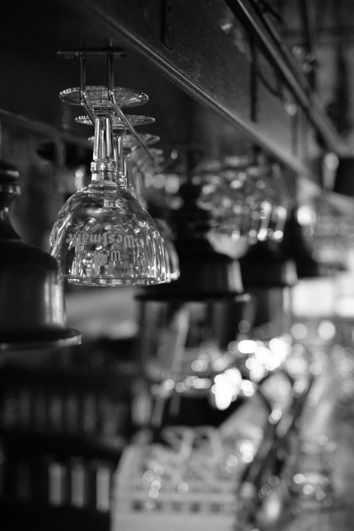 Upside down wine glasses hanging above a bar