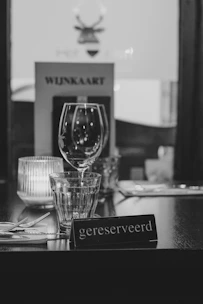 Table setting with 'gereserveerd' sign and wine glasses