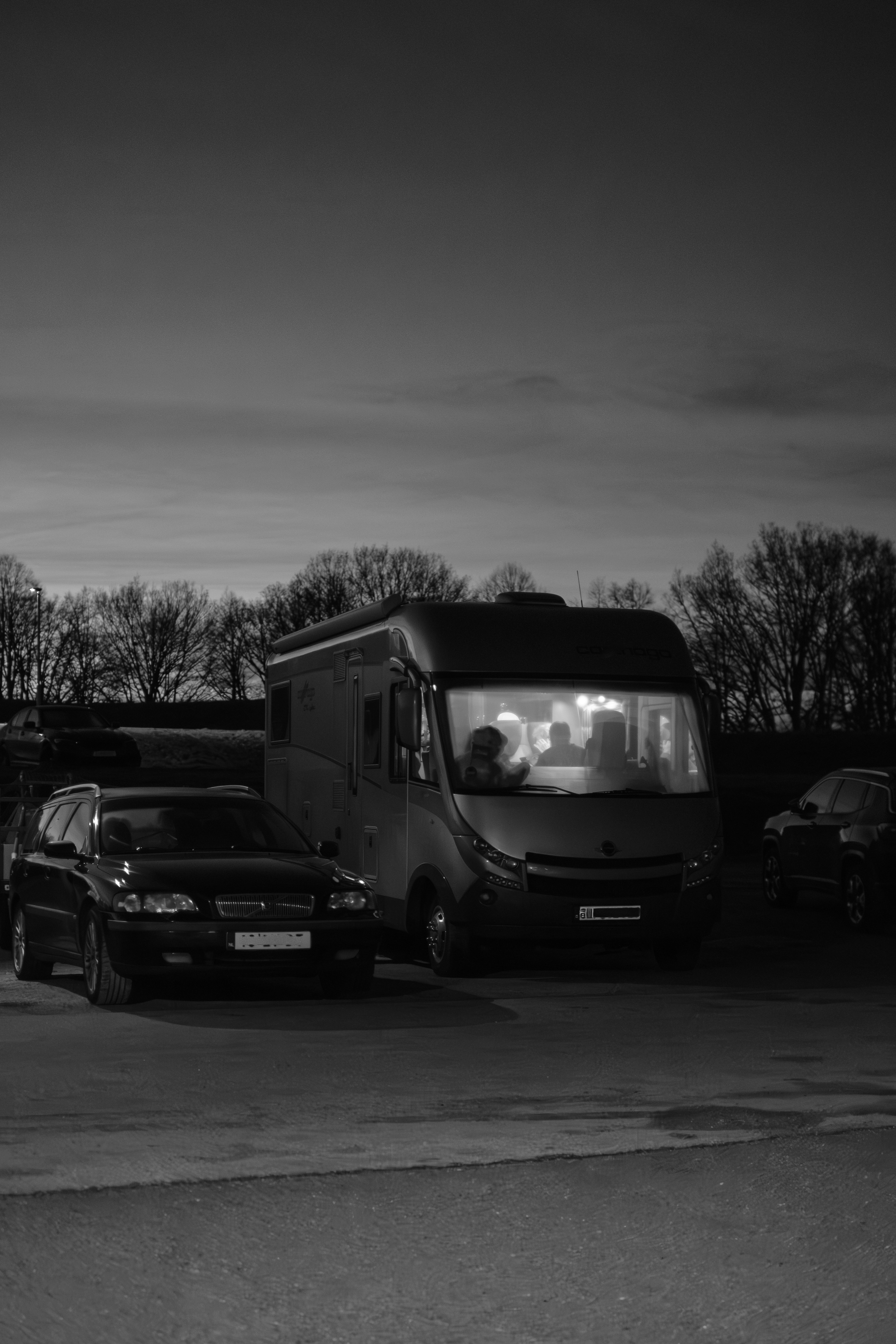 Dos coches y una furgoneta camper al anochecer