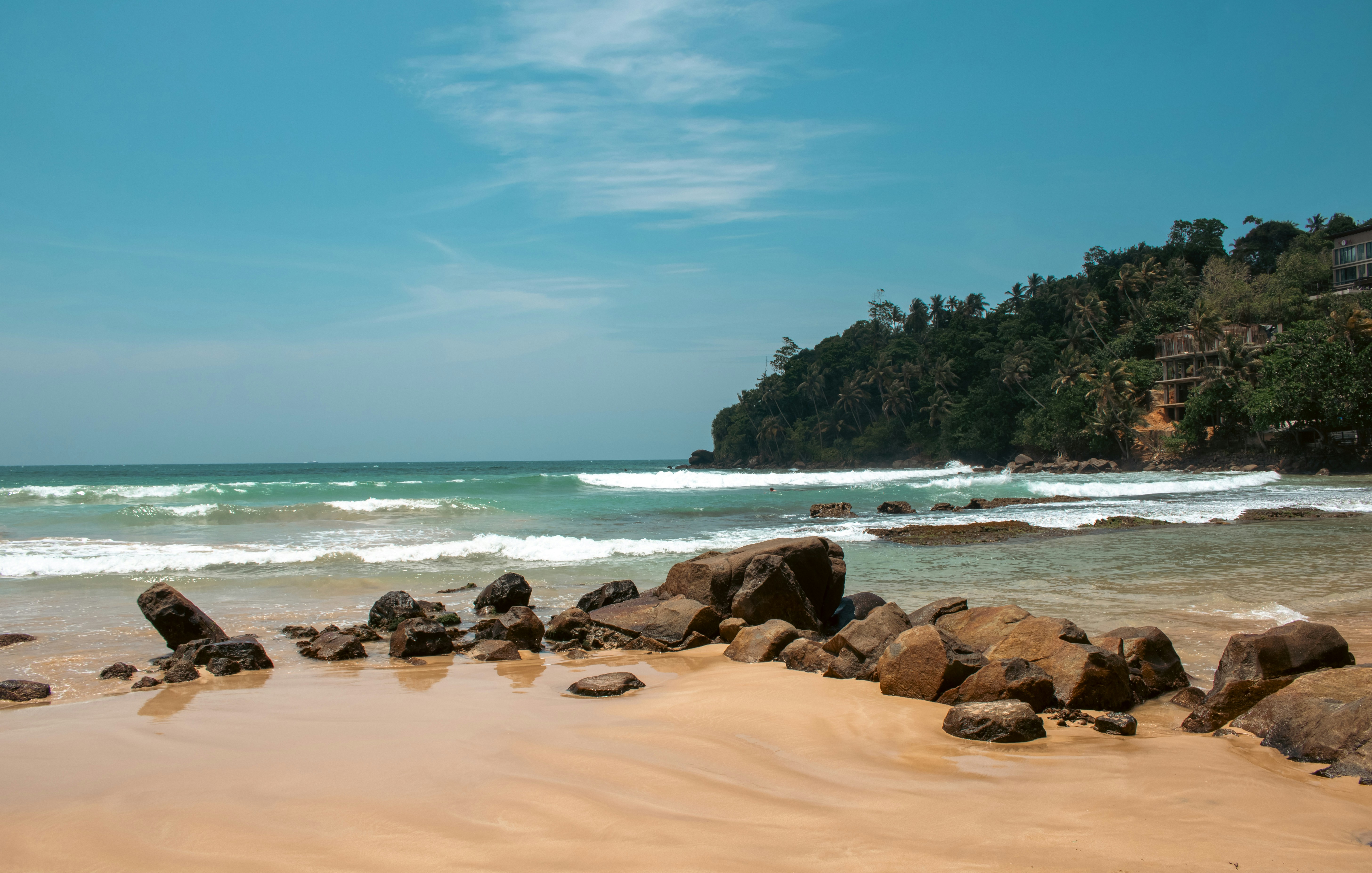 Sandy beach with rocks and turquoise ocean waves