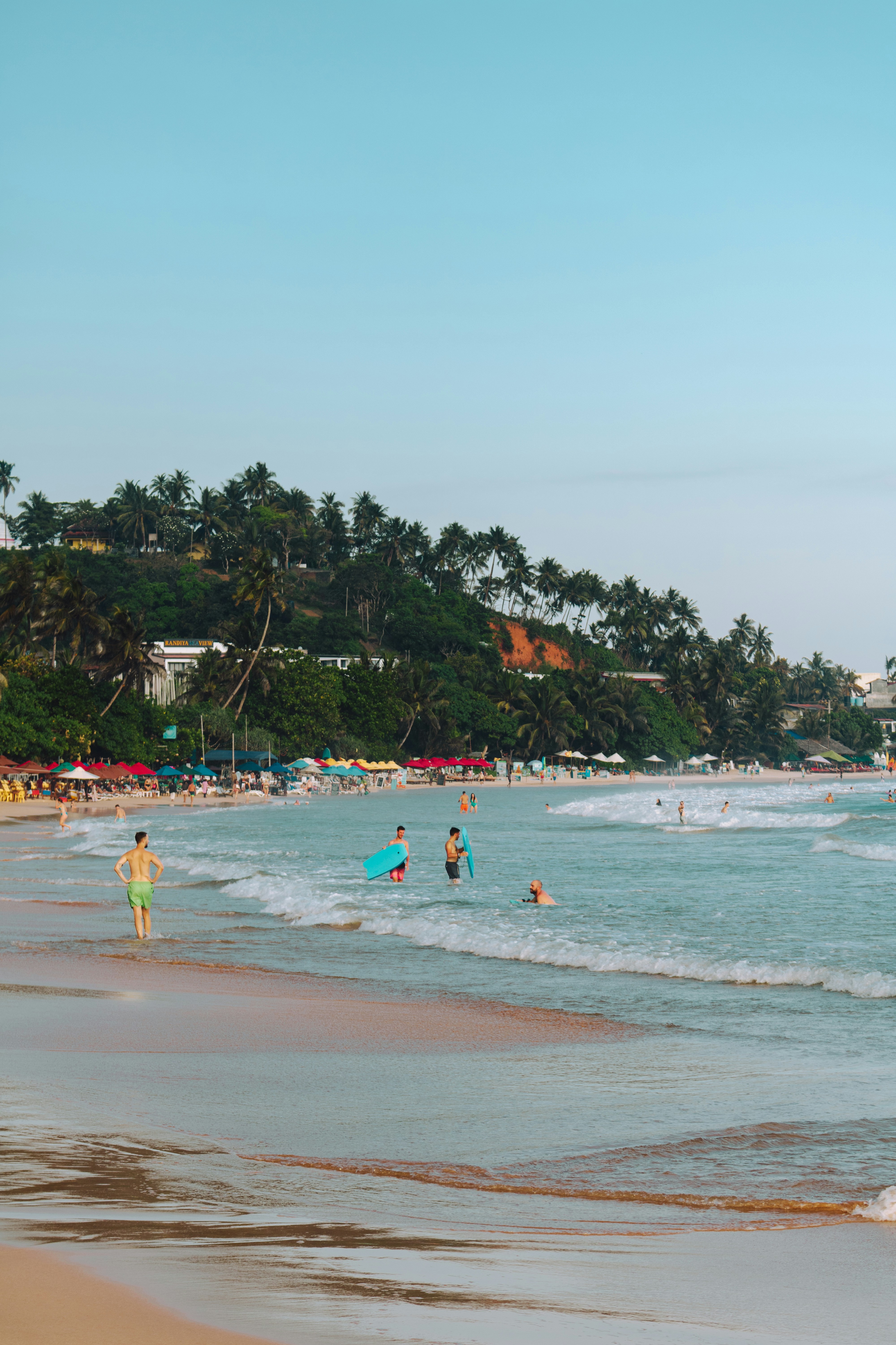 People swimming and relaxing at a tropical beach.