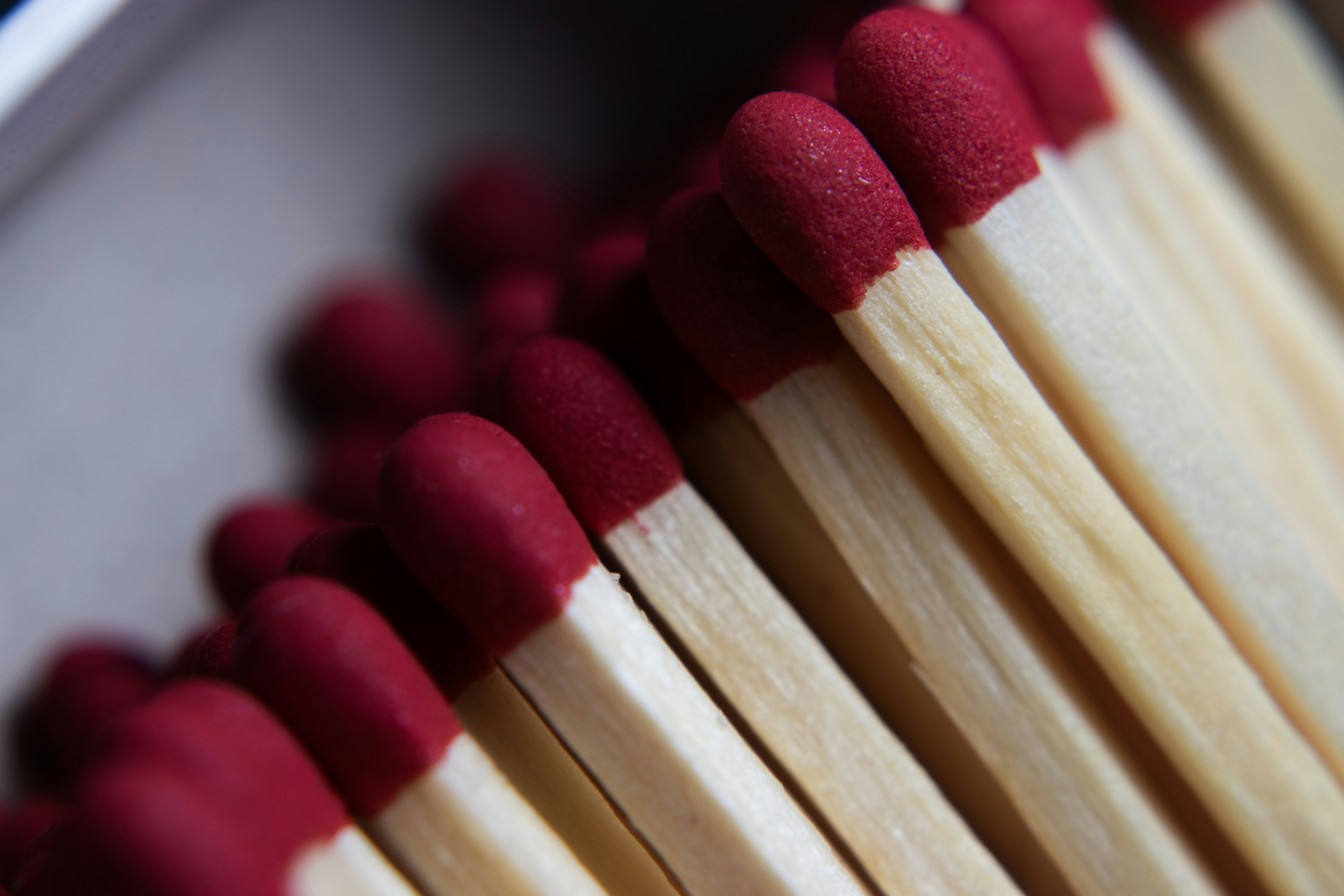 Close-up of red-tipped matches in a box.