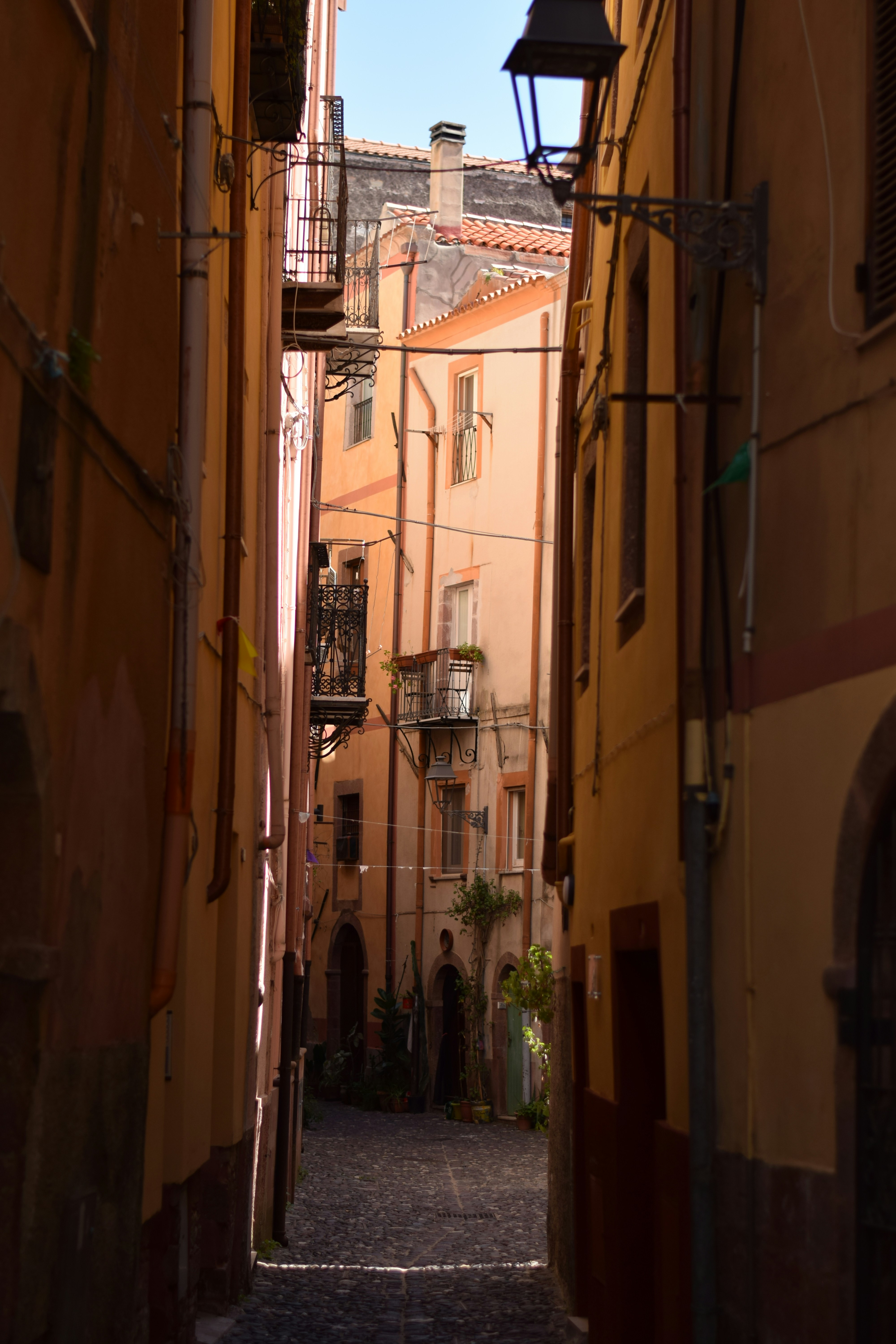 Strada stretta con edifici antichi e pavimentazione in ciottoli.