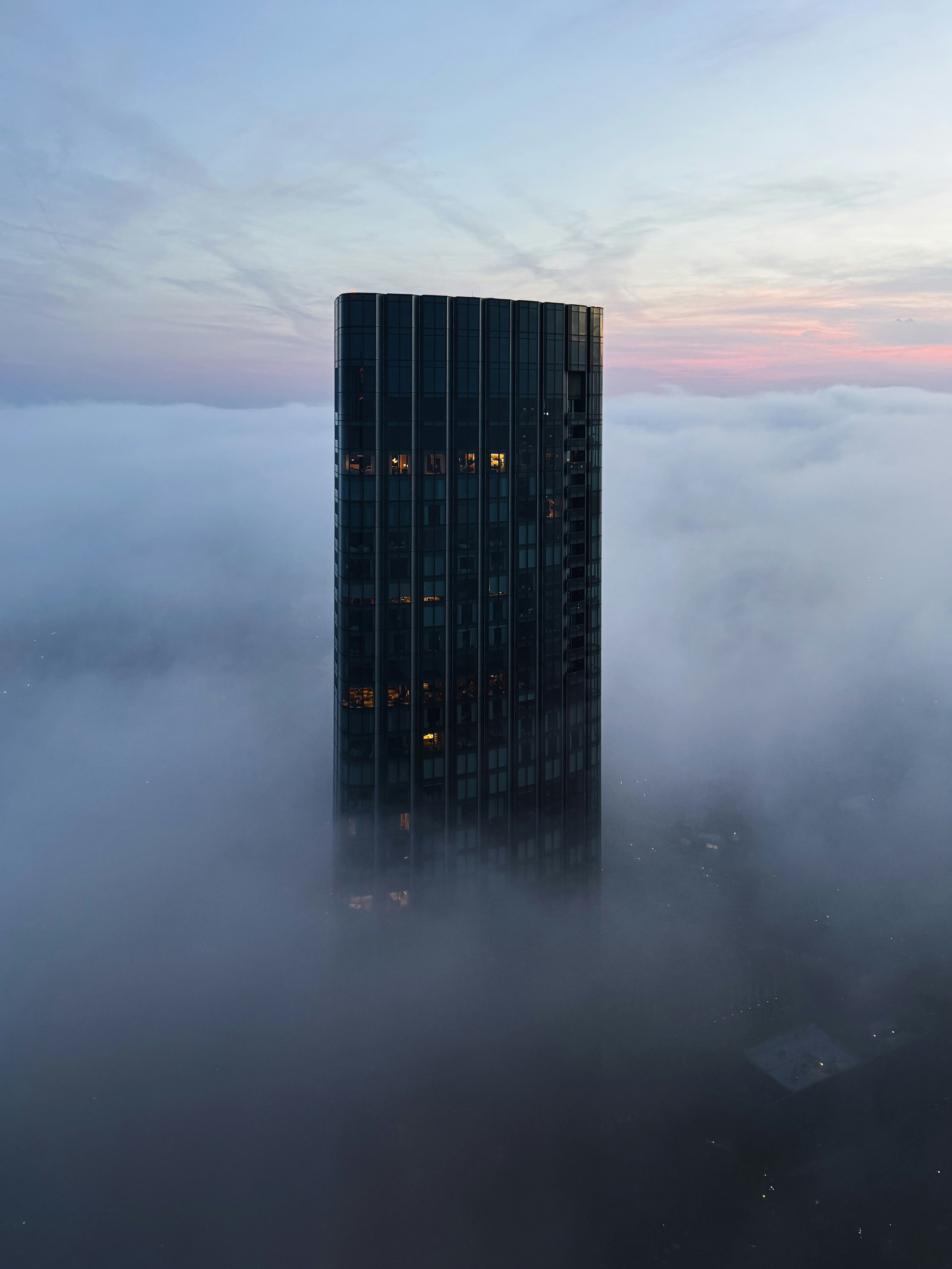 El rascacielos emerge de una densa niebla al amanecer