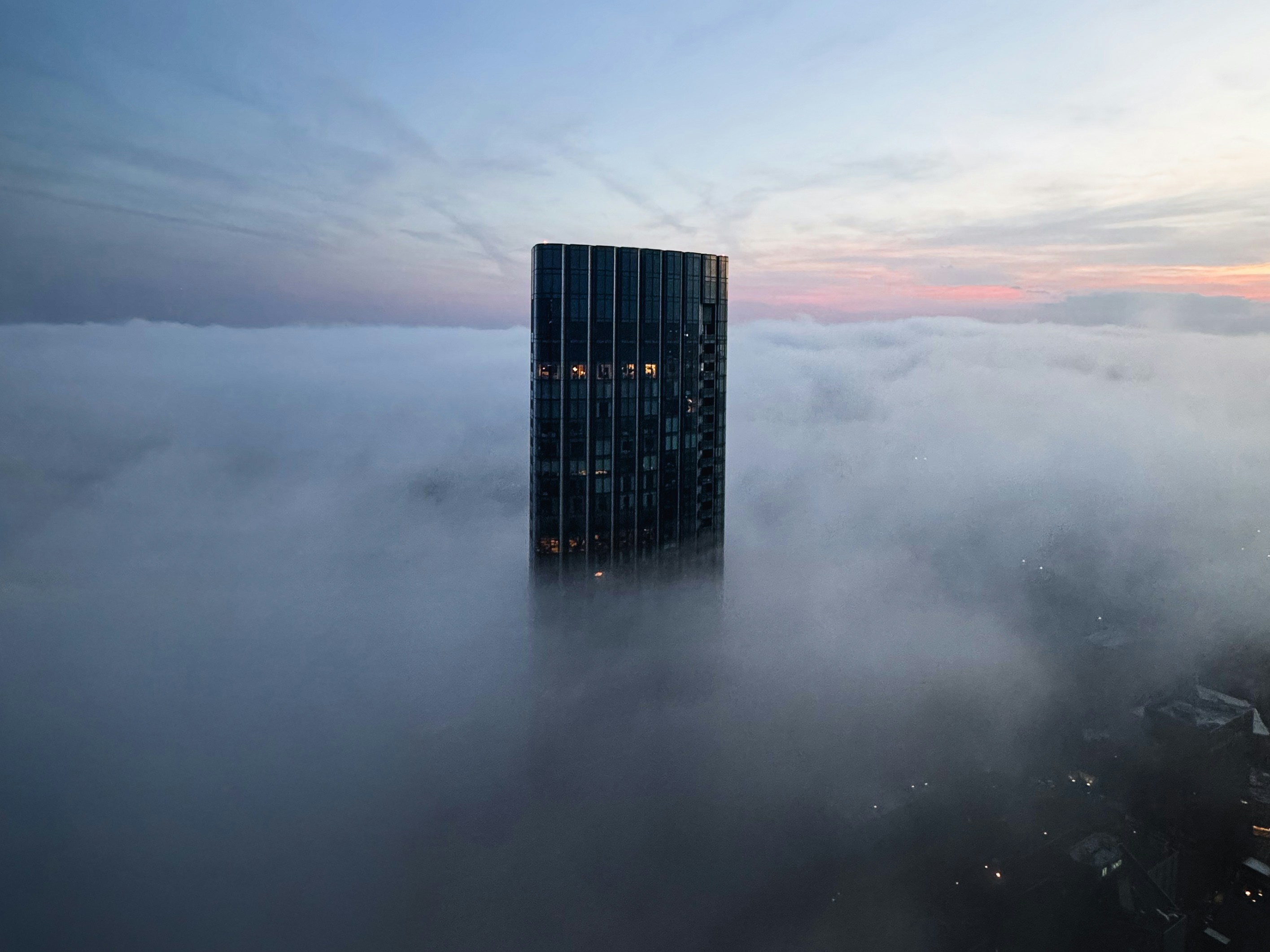 El rascacielos emerge de una densa niebla al amanecer