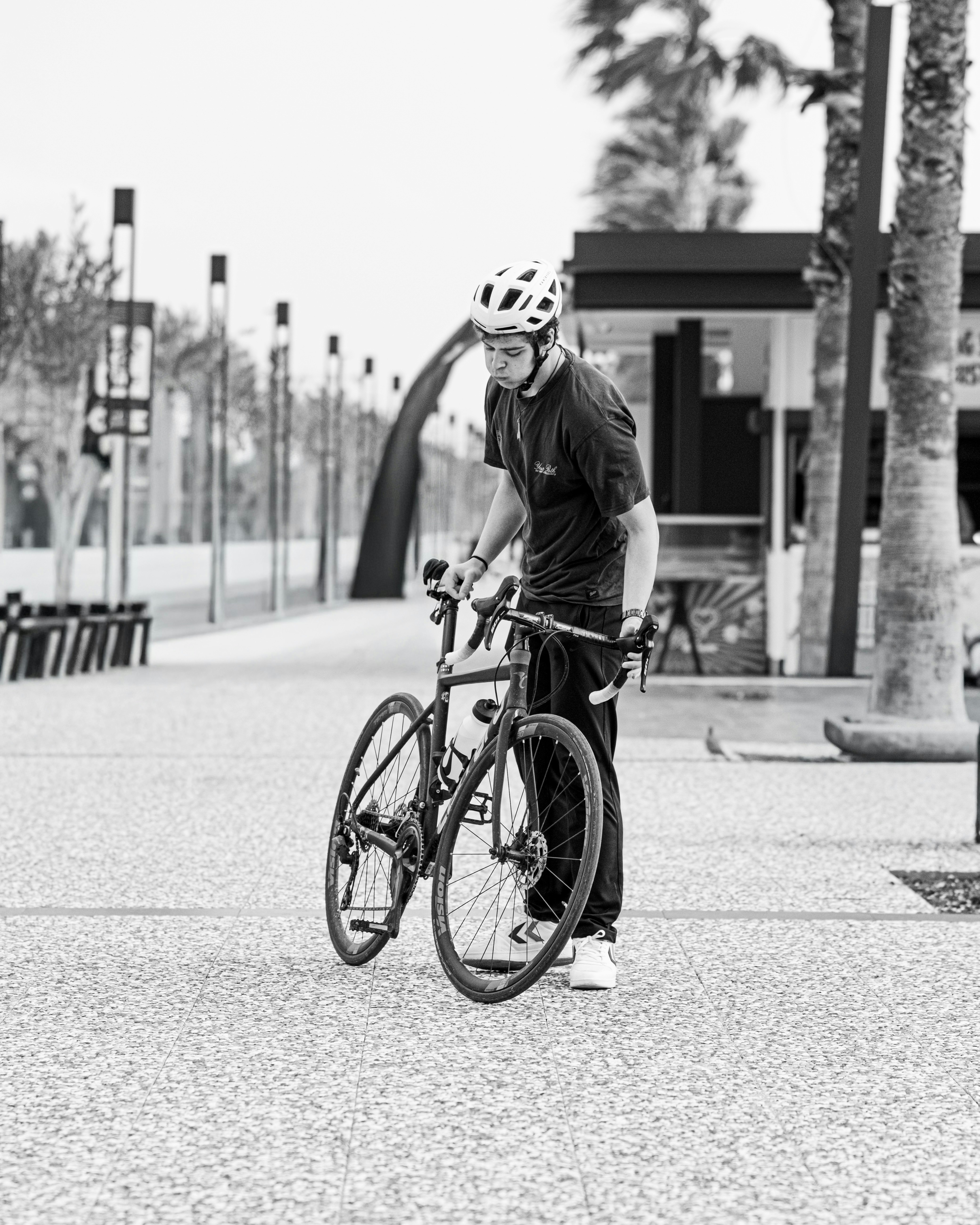 Man with bicycle on paved walkway outdoors