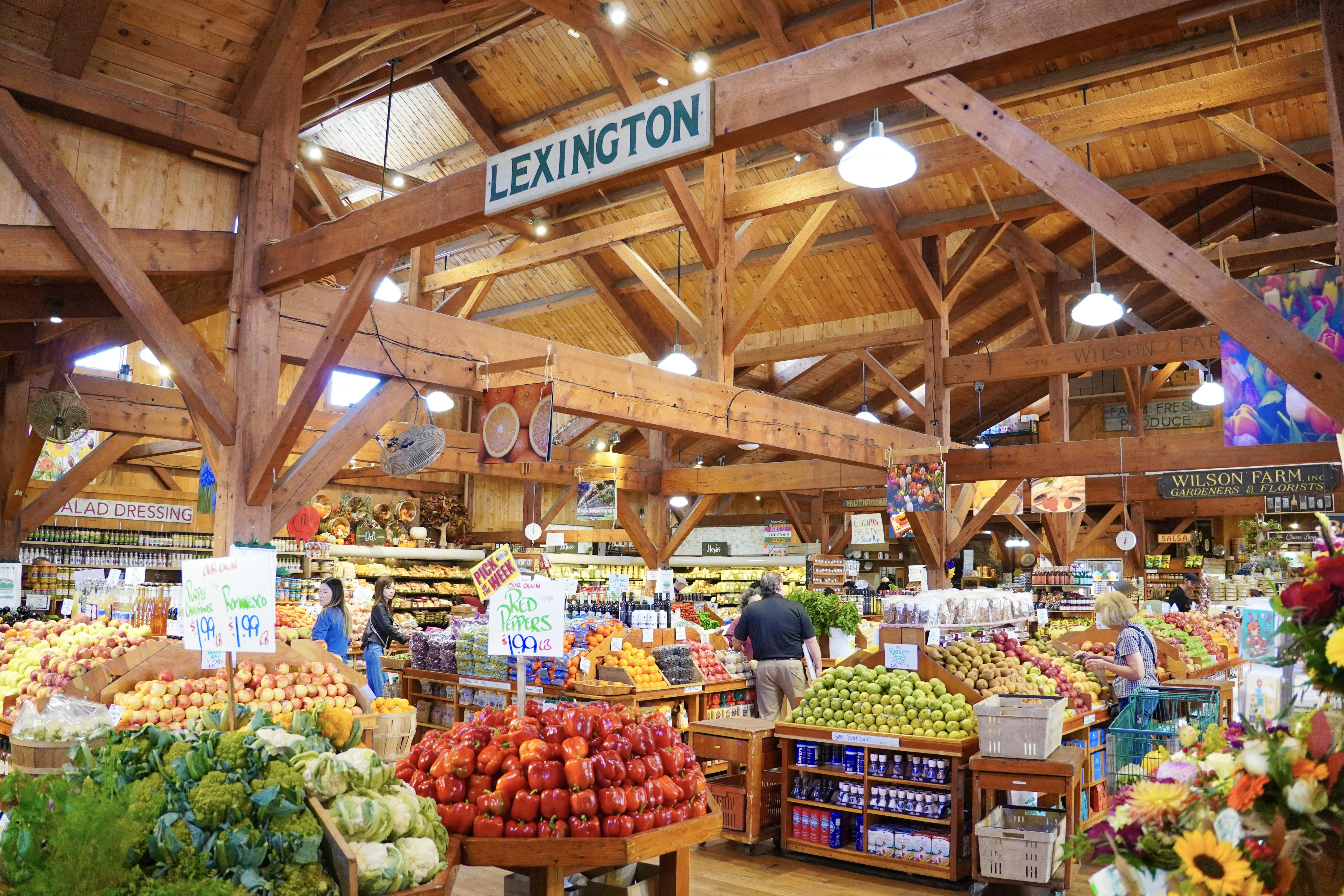 Interior of a bustling farmers market with abundant fresh produce.