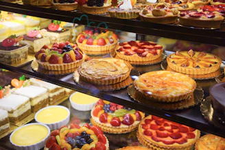 Display case filled with assorted cakes and fruit tarts