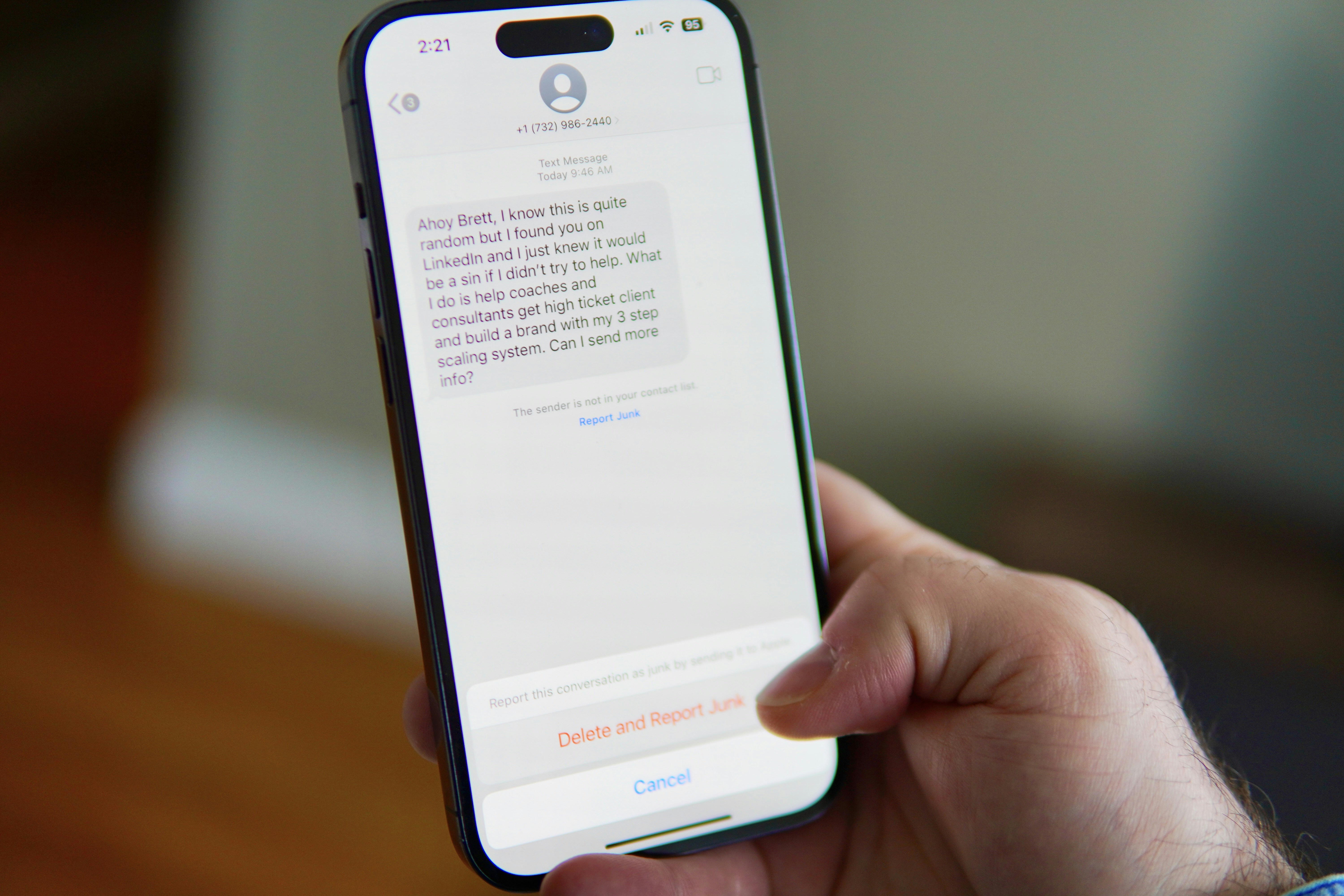 Hand holding a smartphone displaying a text message conversation.