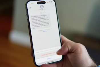 Hand holding a smartphone displaying a text message conversation.