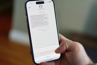 Hand holding a smartphone displaying a text message conversation.