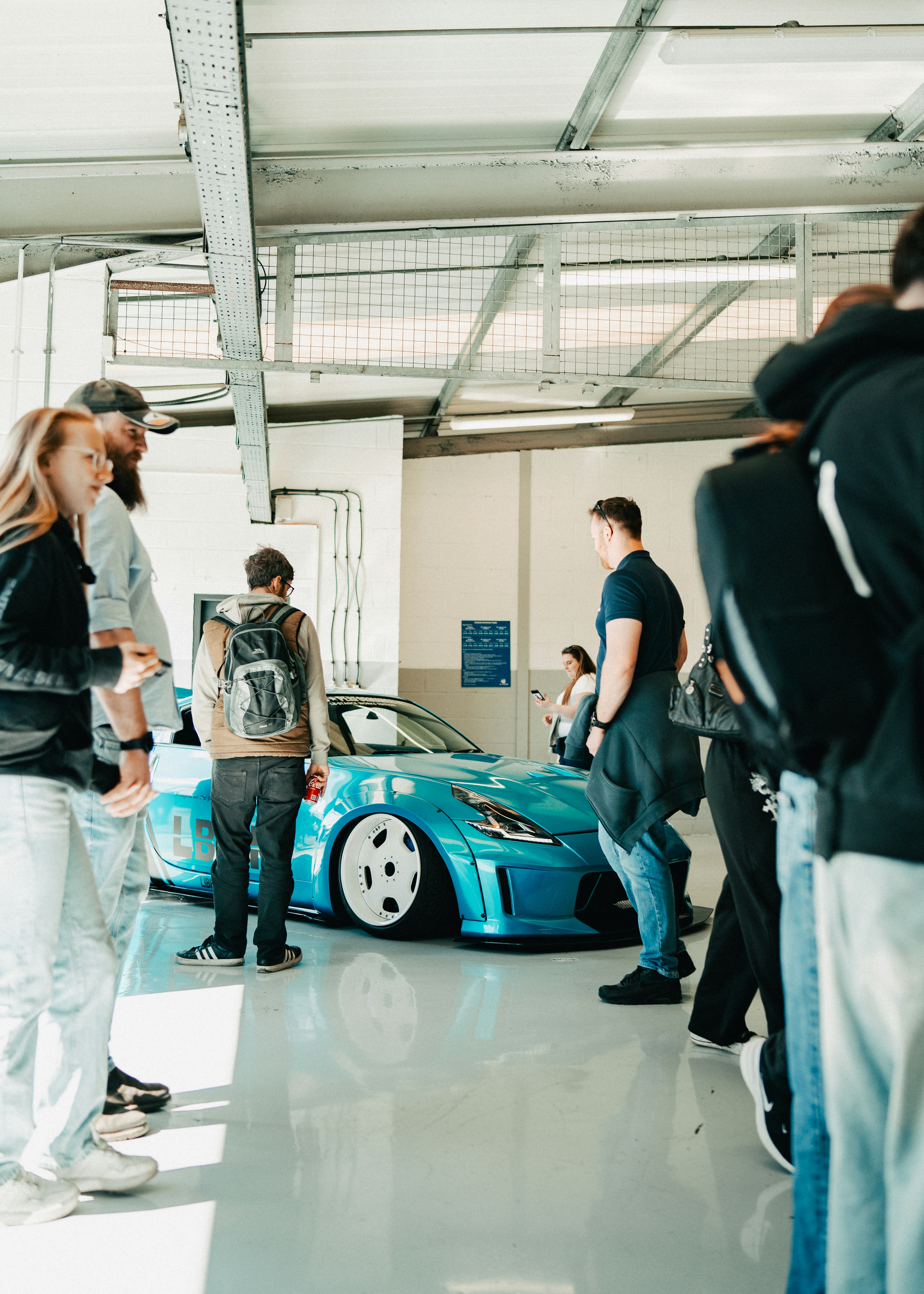 People gathered around a custom blue sports car.