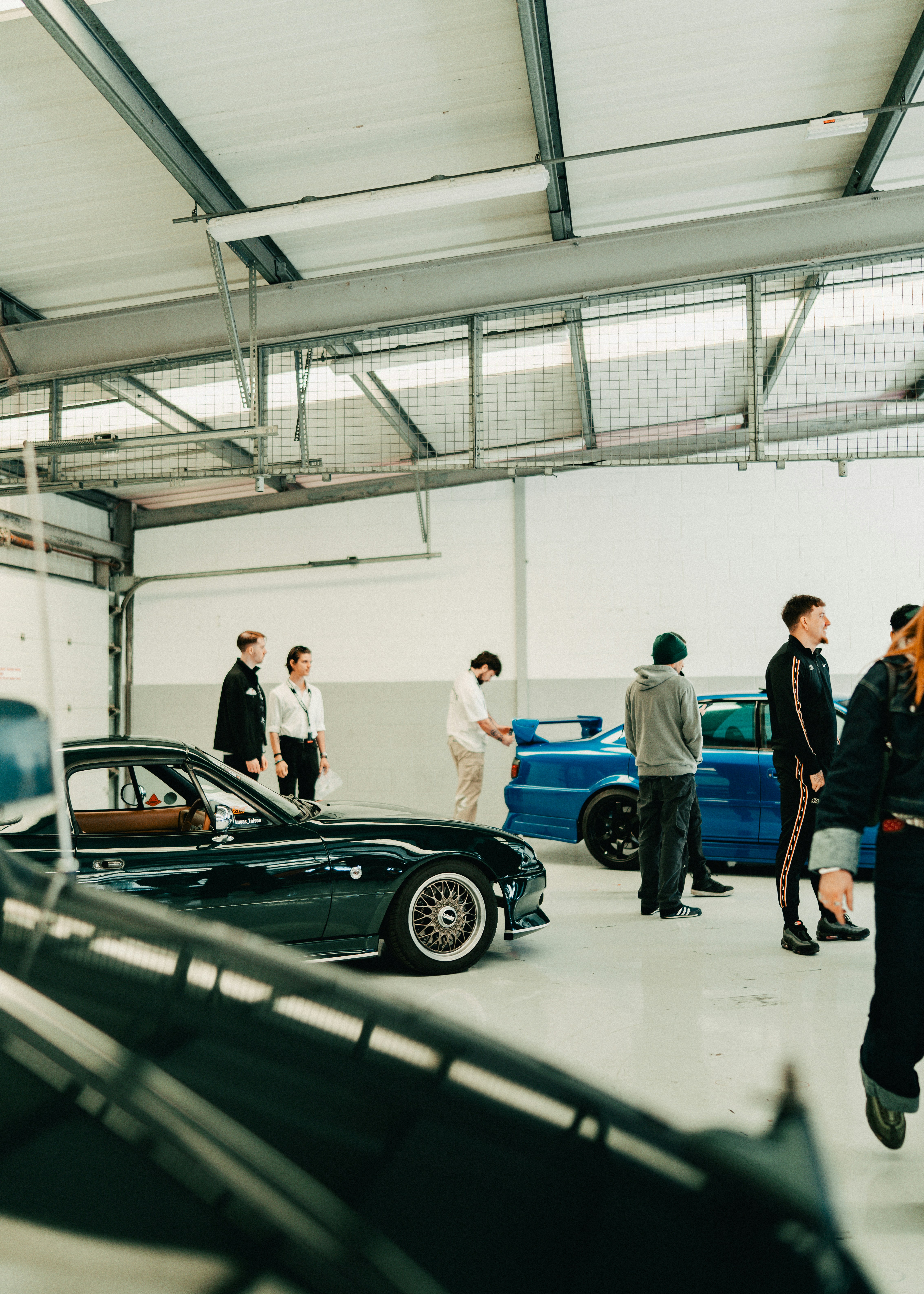 People gathered in a modern garage with cars