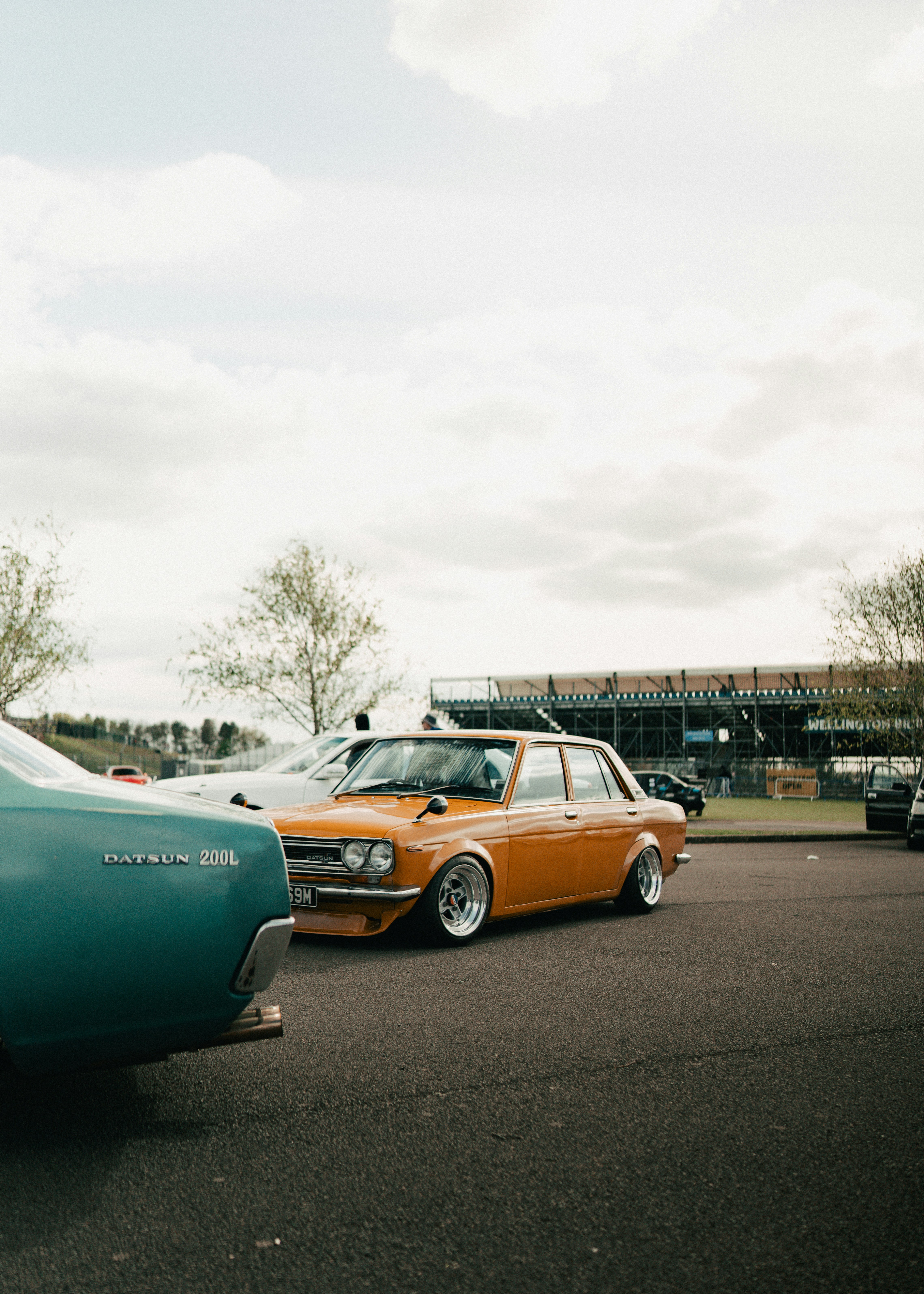 An orange datsun 510 sedan parked outdoors