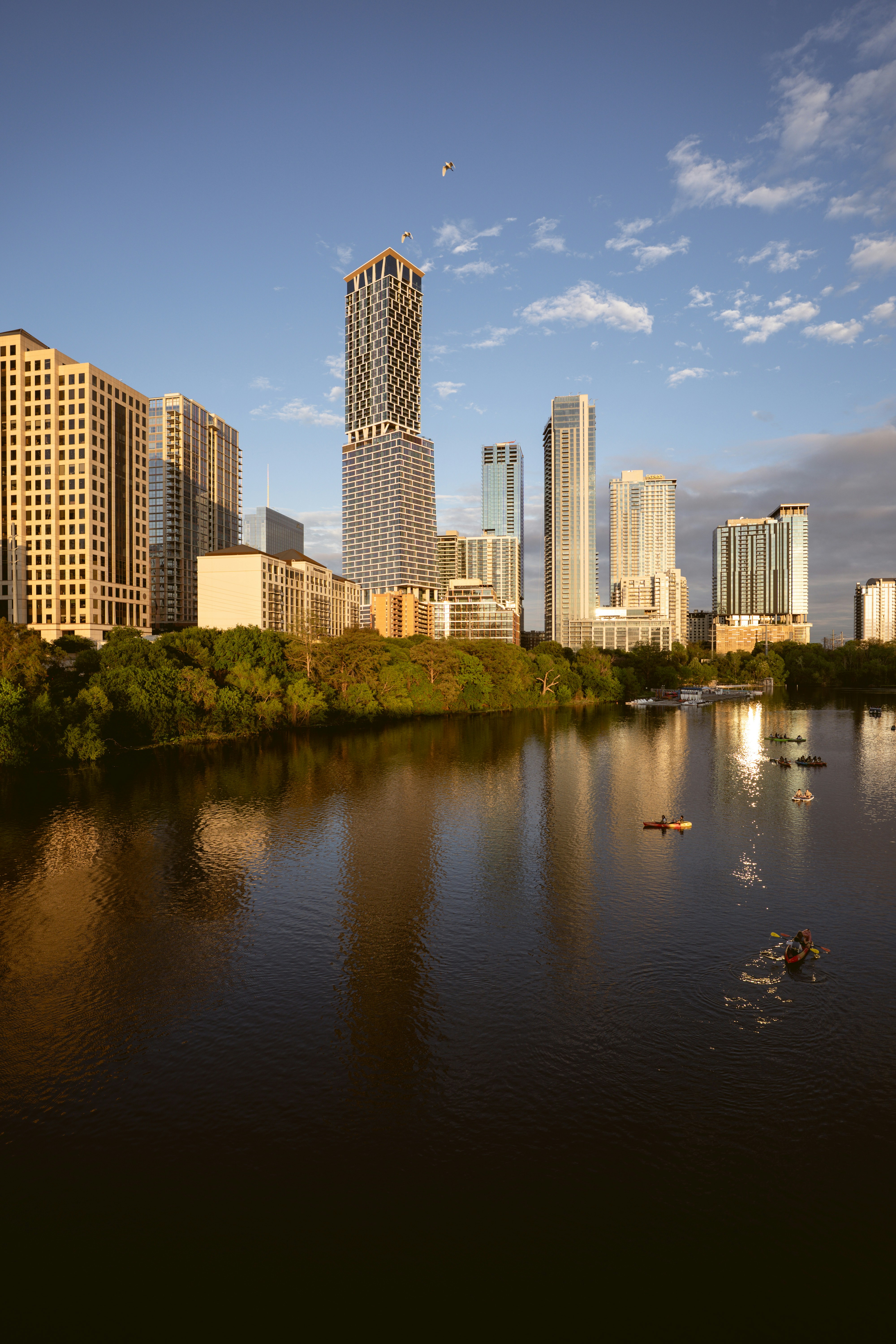 City skyline reflected in a calm river at sunset