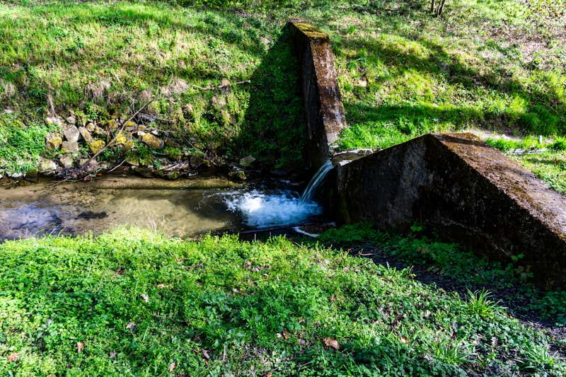Wasser fließt aus einem Rohr in ein Becken