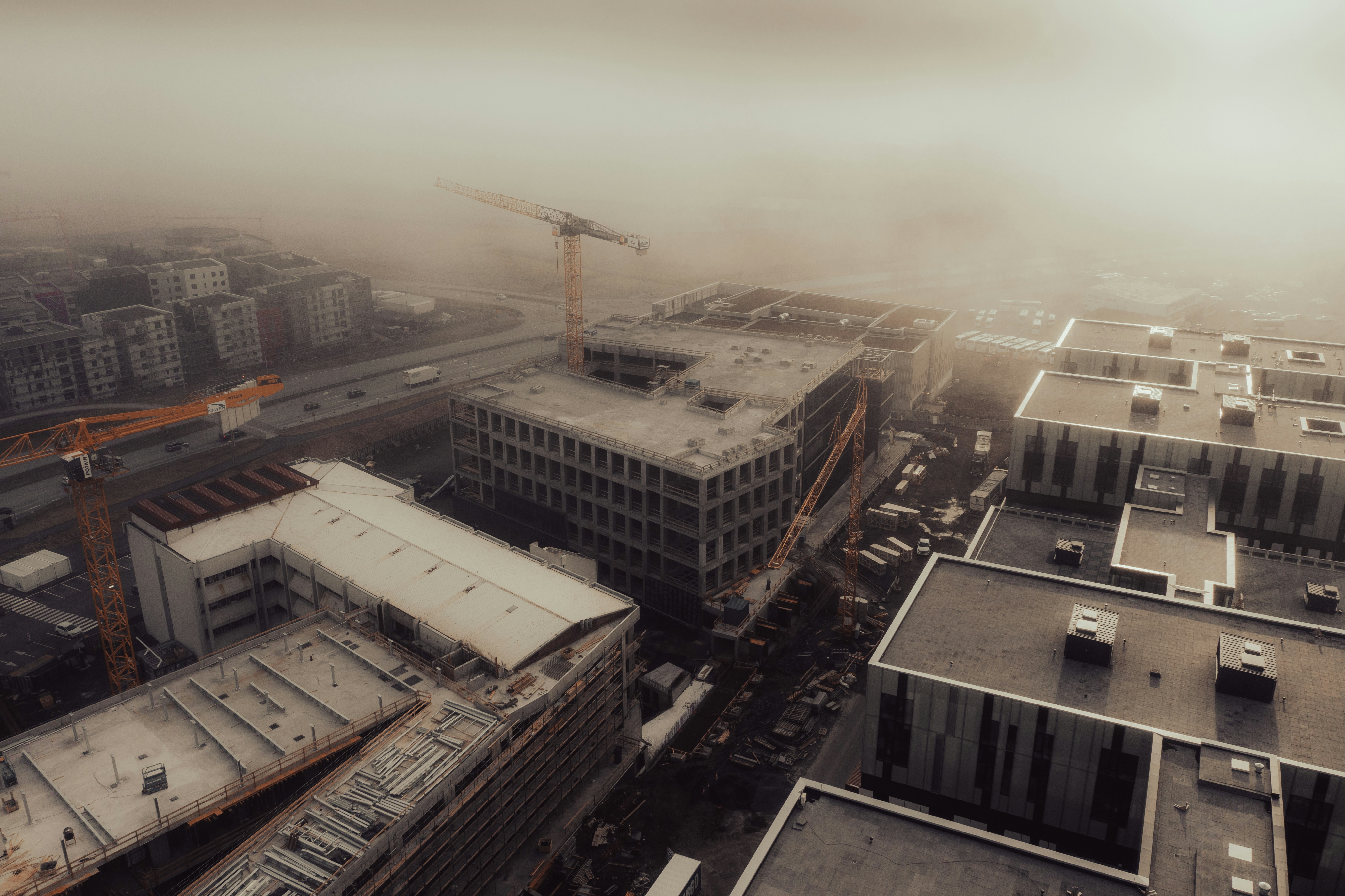Construction site with cranes on a foggy day