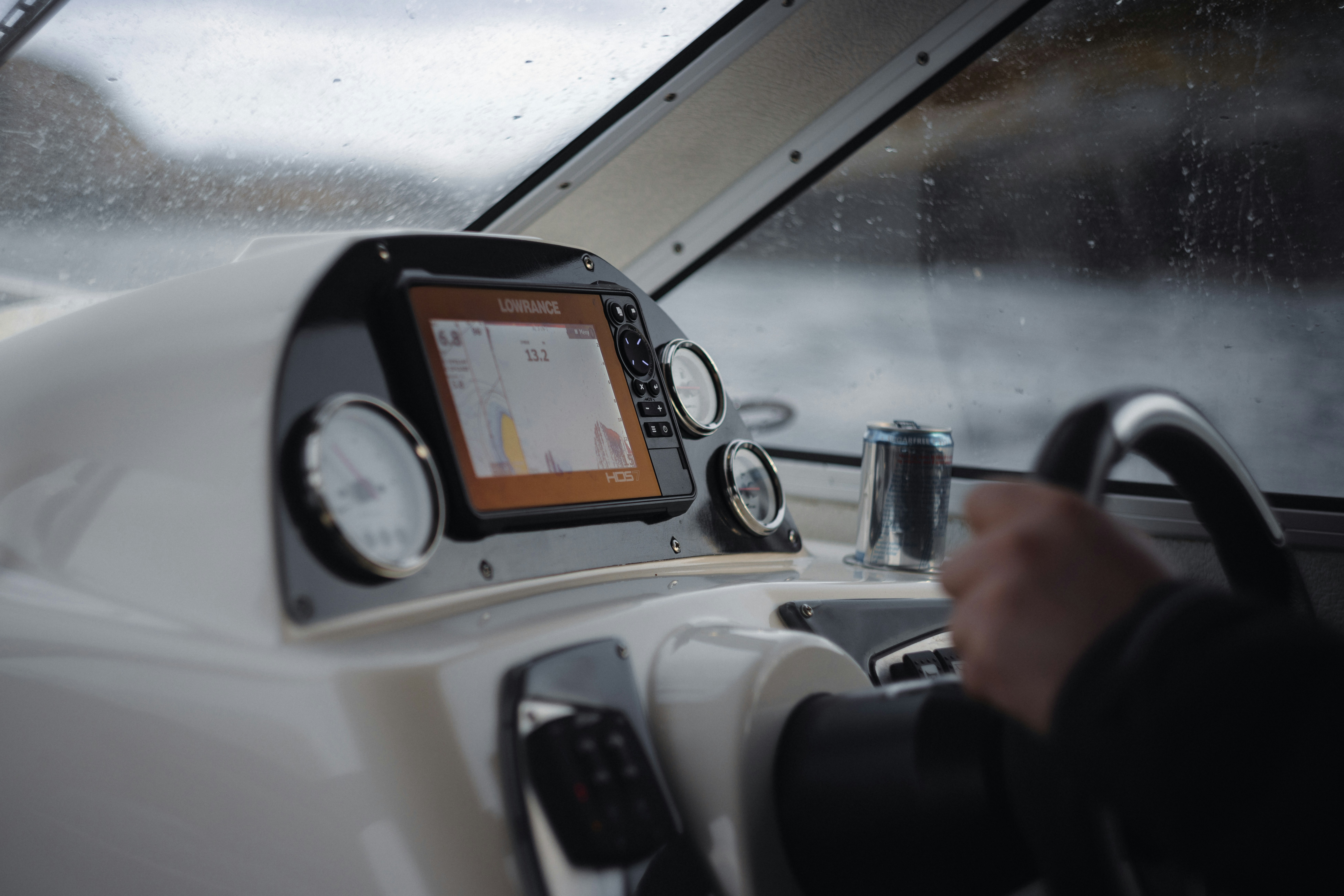 Person steering a boat with navigation screen