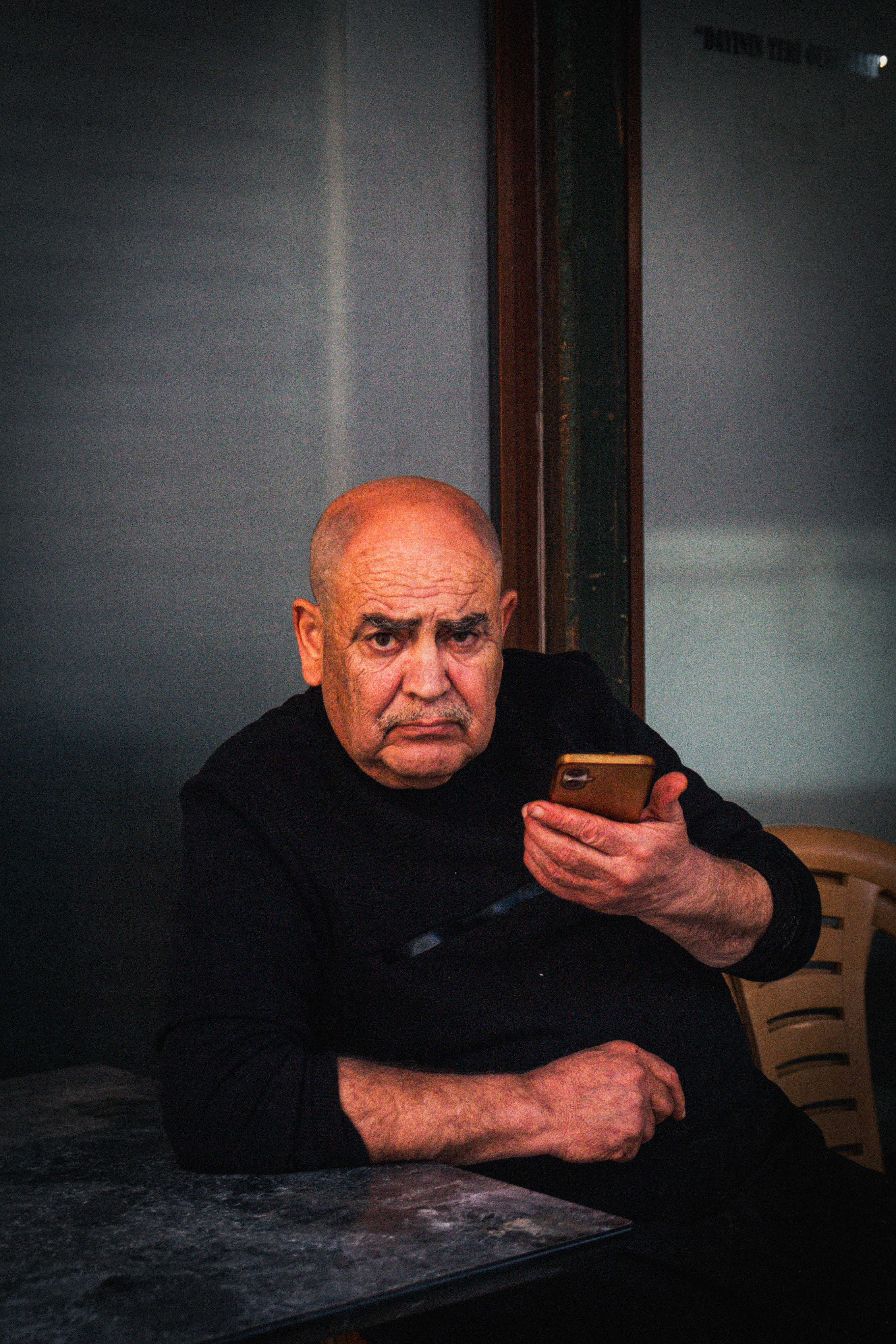 Elderly man with a smartphone looking at camera