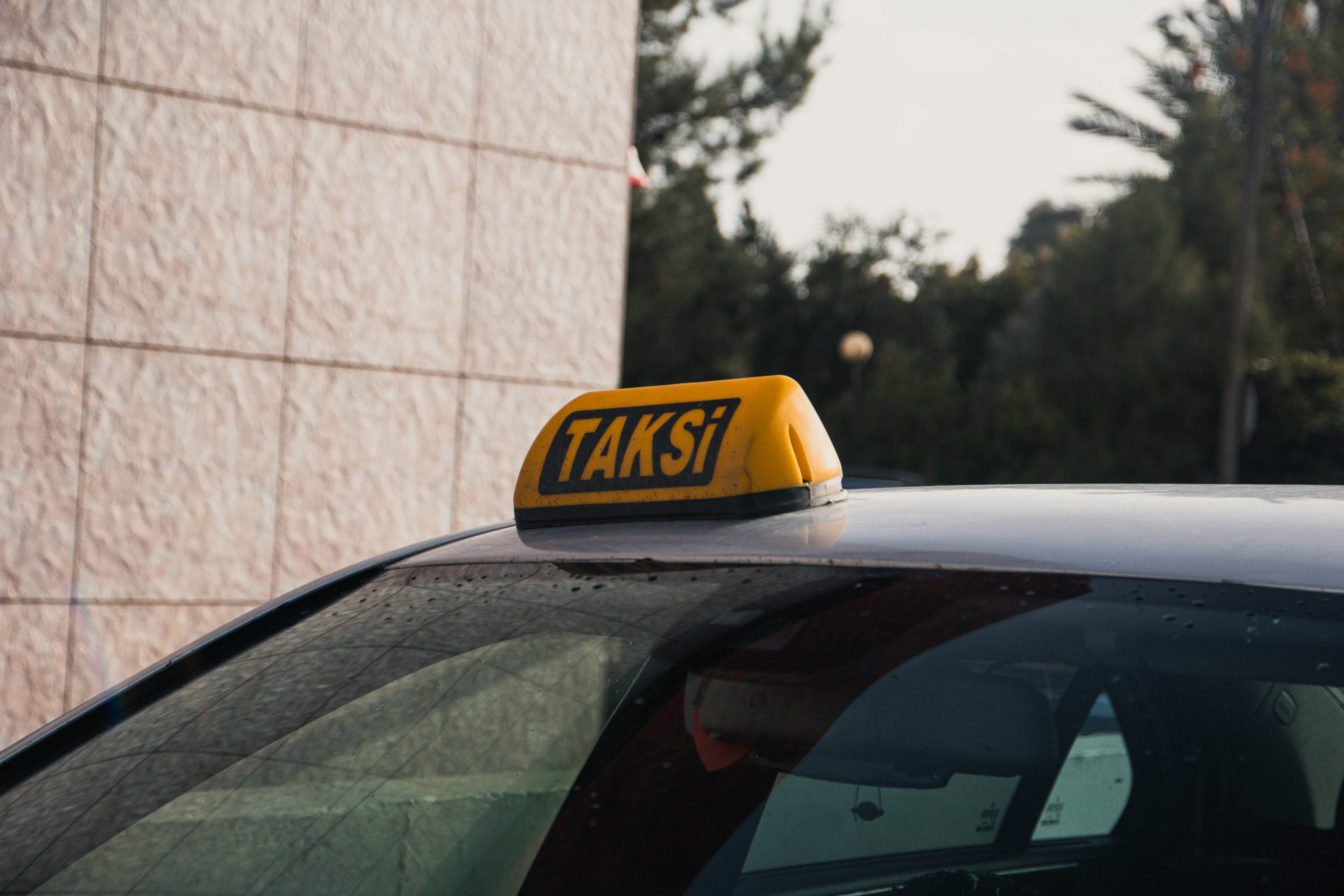 Tanda taksi kuning di atap mobil.