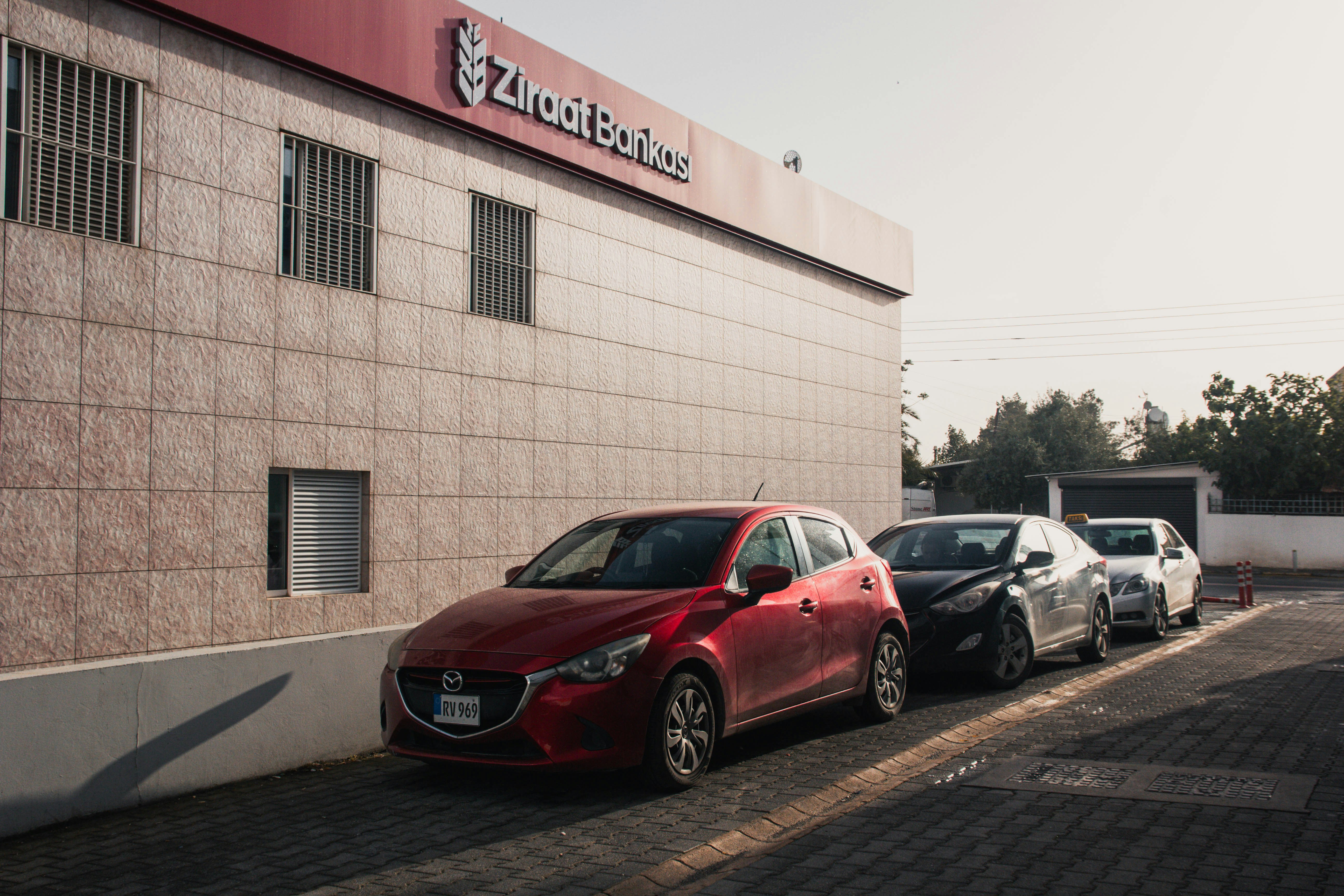 Cars parked in a line outside a bank.