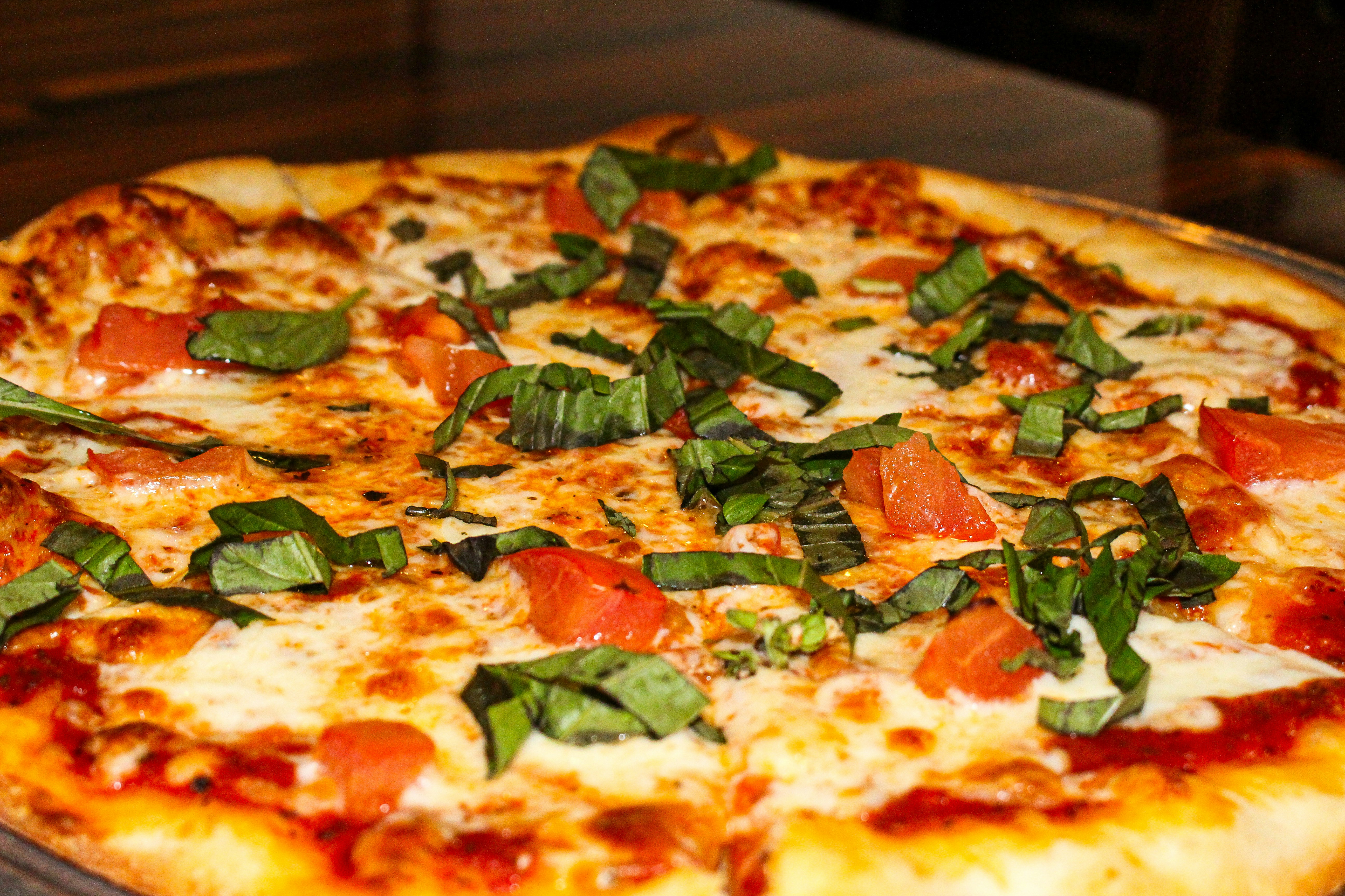 A delicious pizza topped with fresh basil and tomatoes