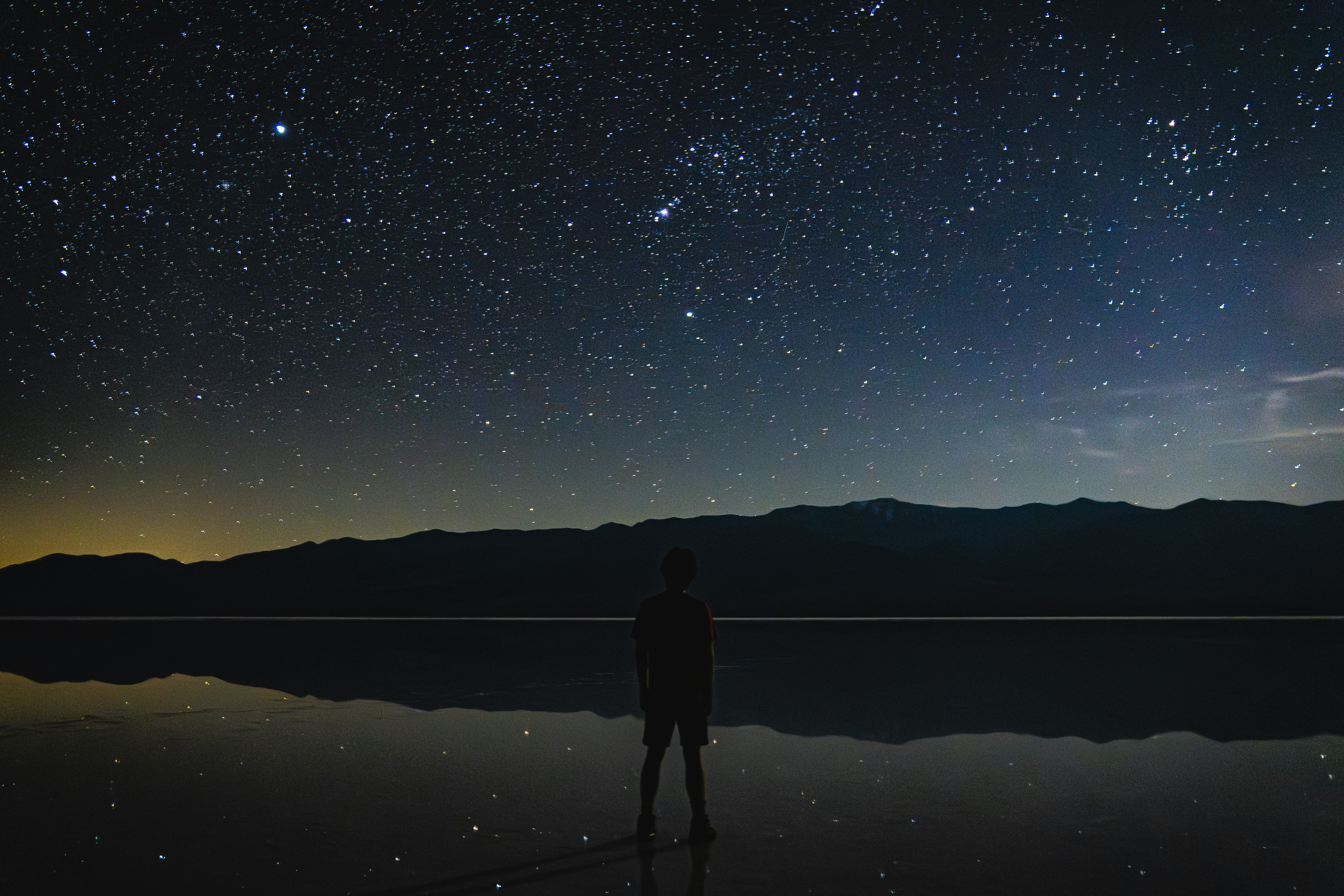 A person stands under a starry night sky. - 相关推荐