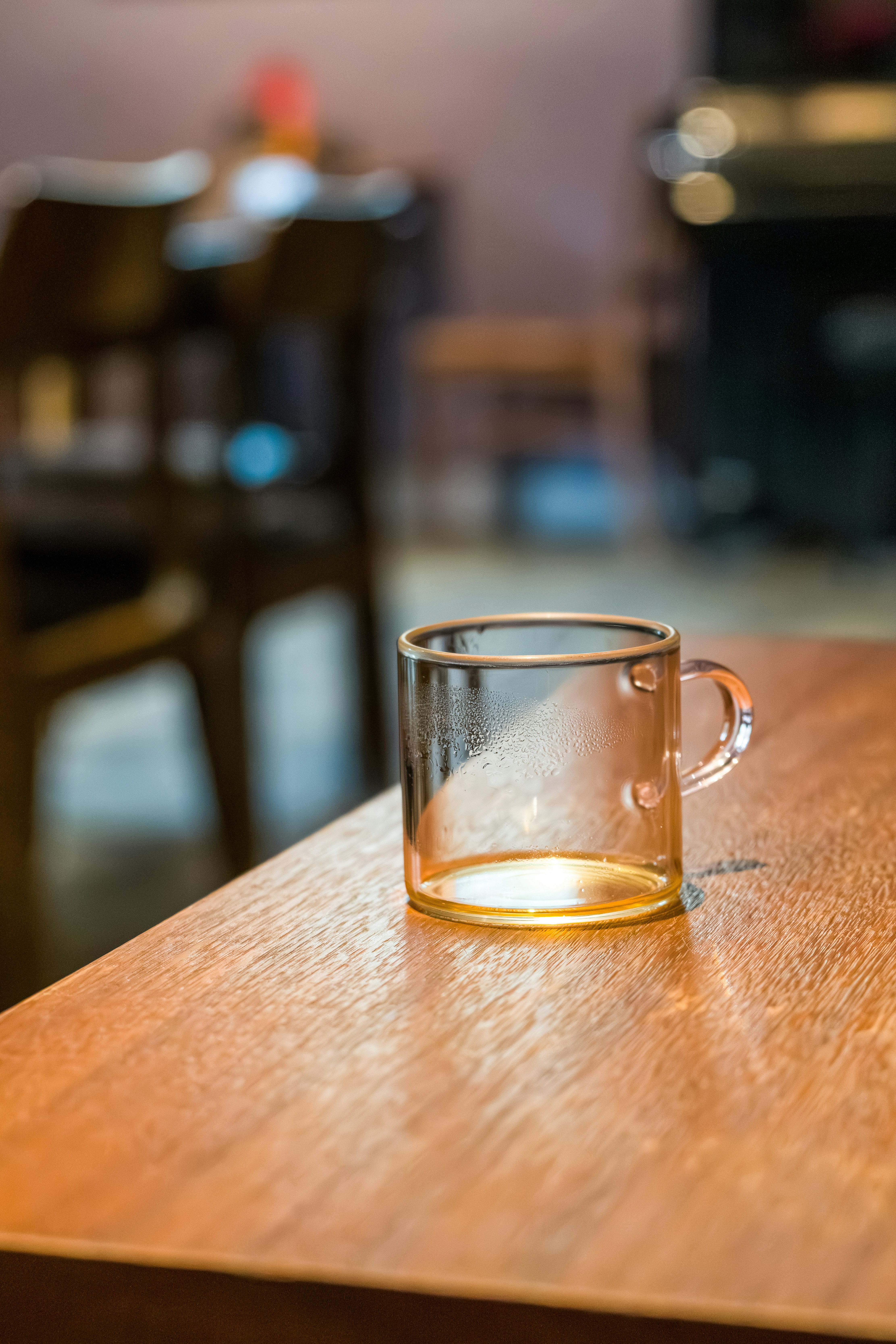A clear glass mug sits on a wooden table.