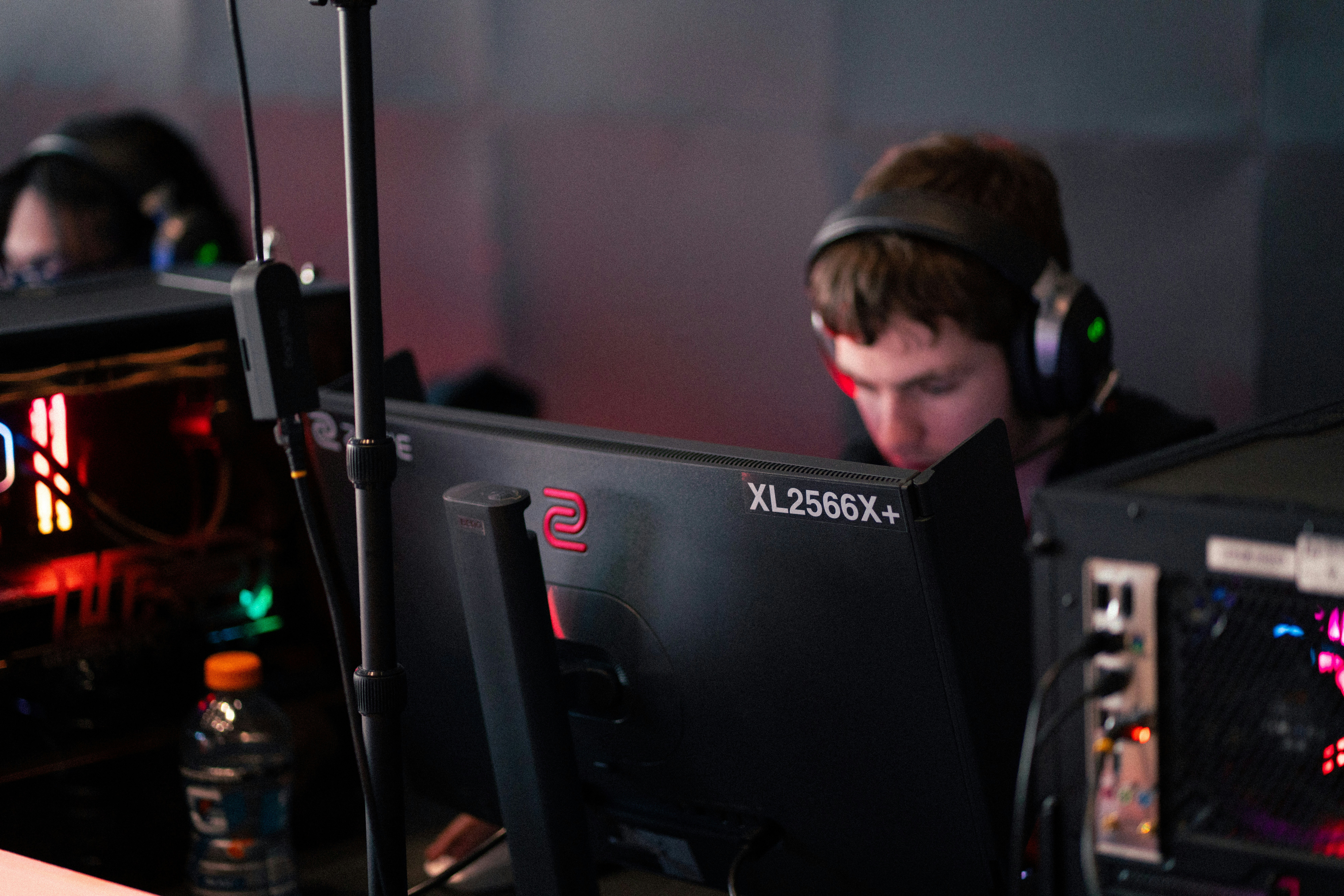 Young man wearing headphones focused on computer screen