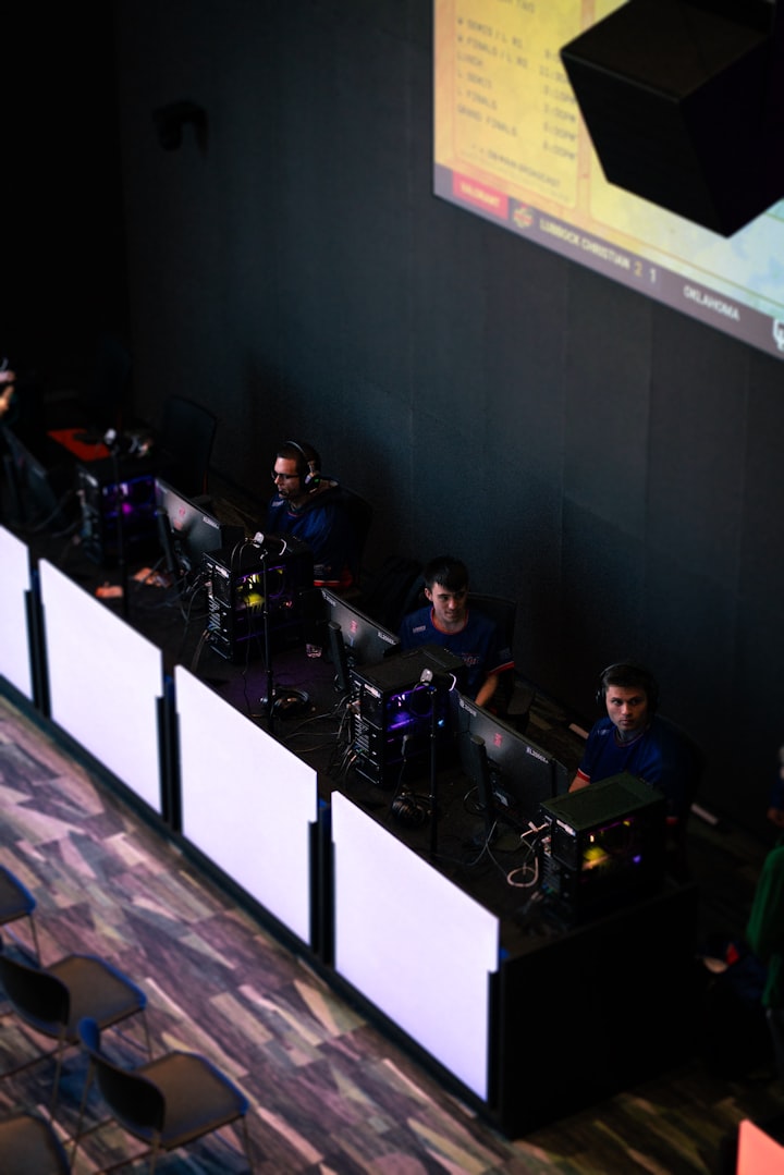 Competitive players at illuminated workstations in a dim esports arena