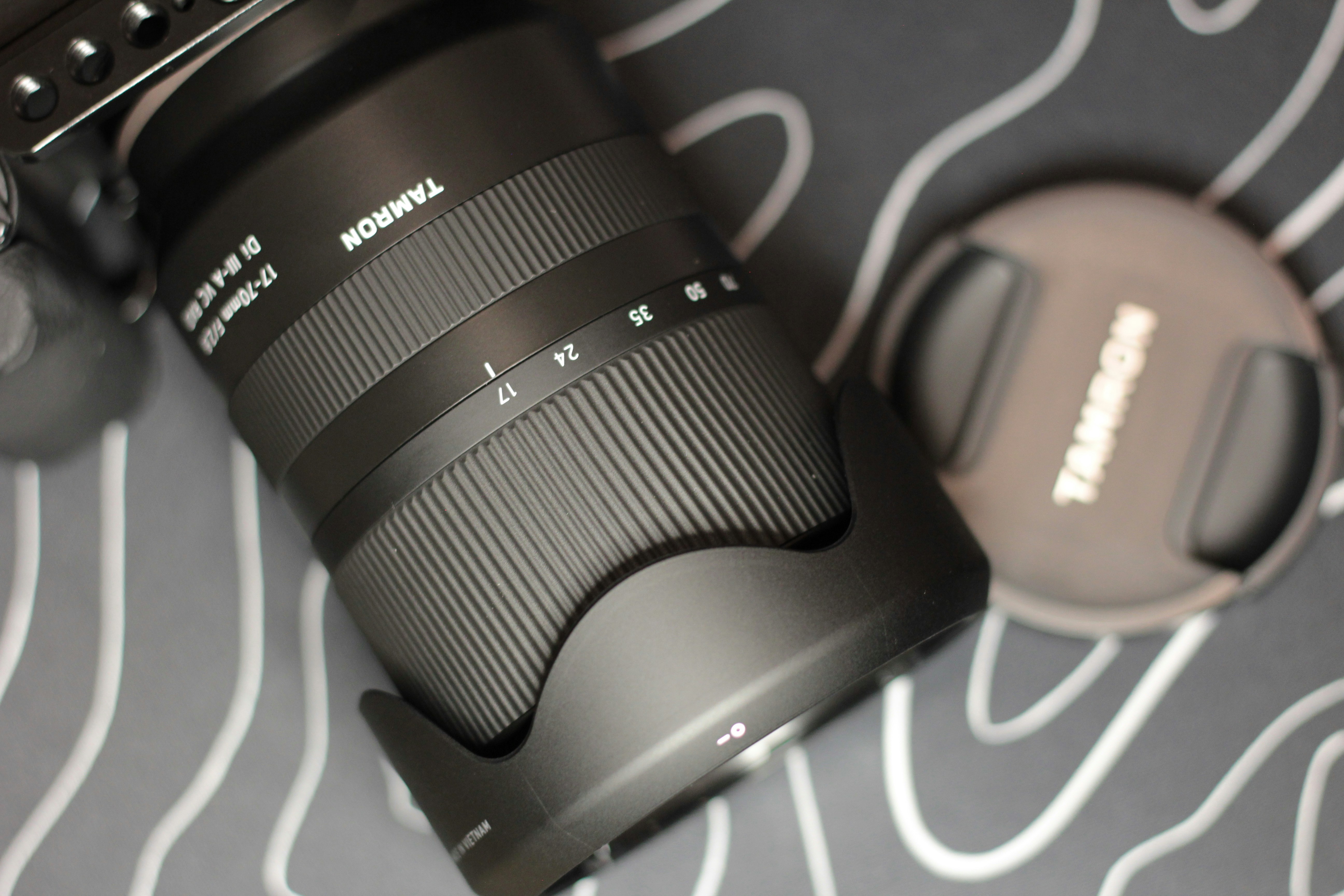 Un objectif caméra Tamron noir avec un capuchon d’objectif.