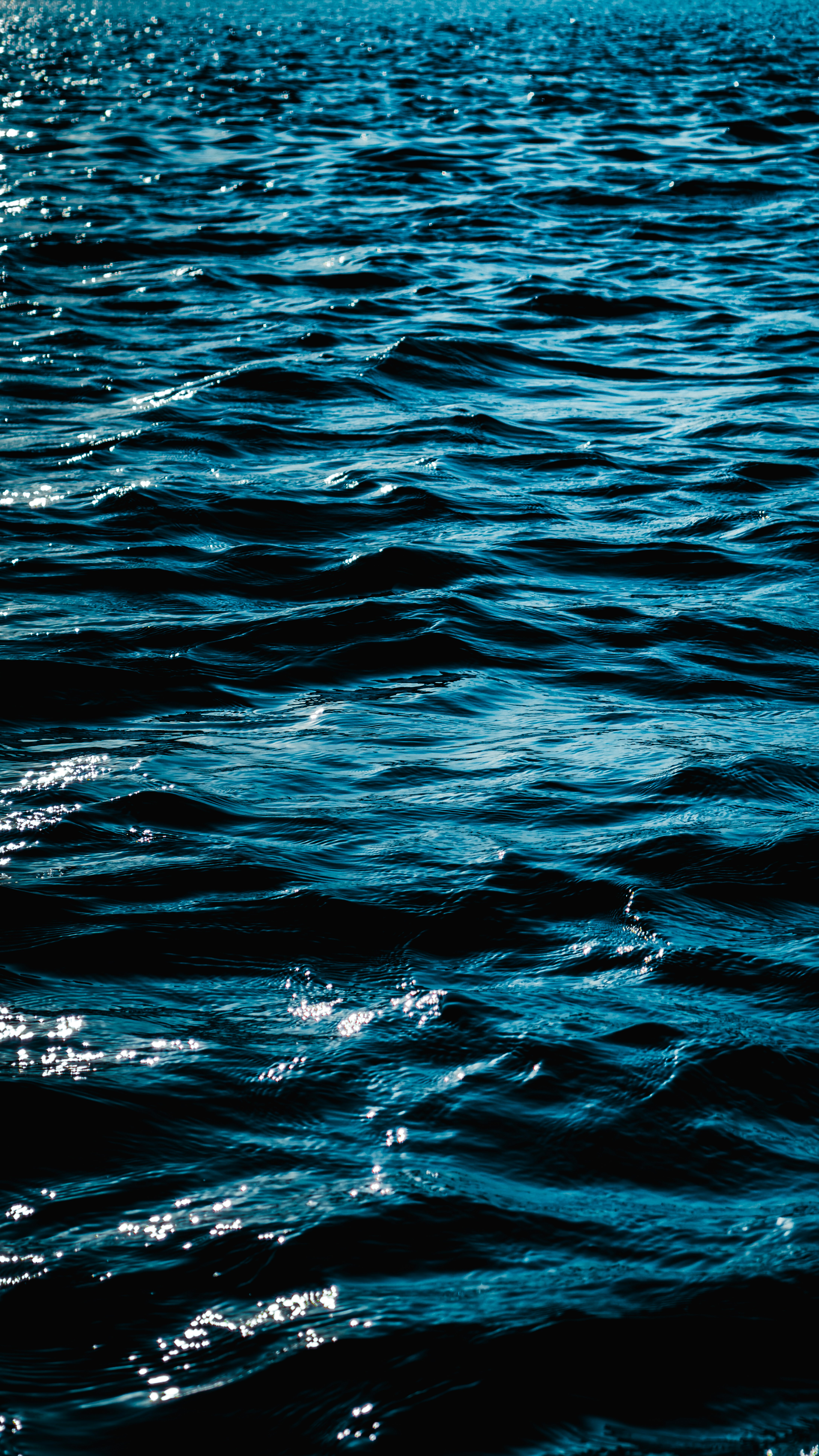 Onde dell'oceano blu scuro con il sole che brilla
