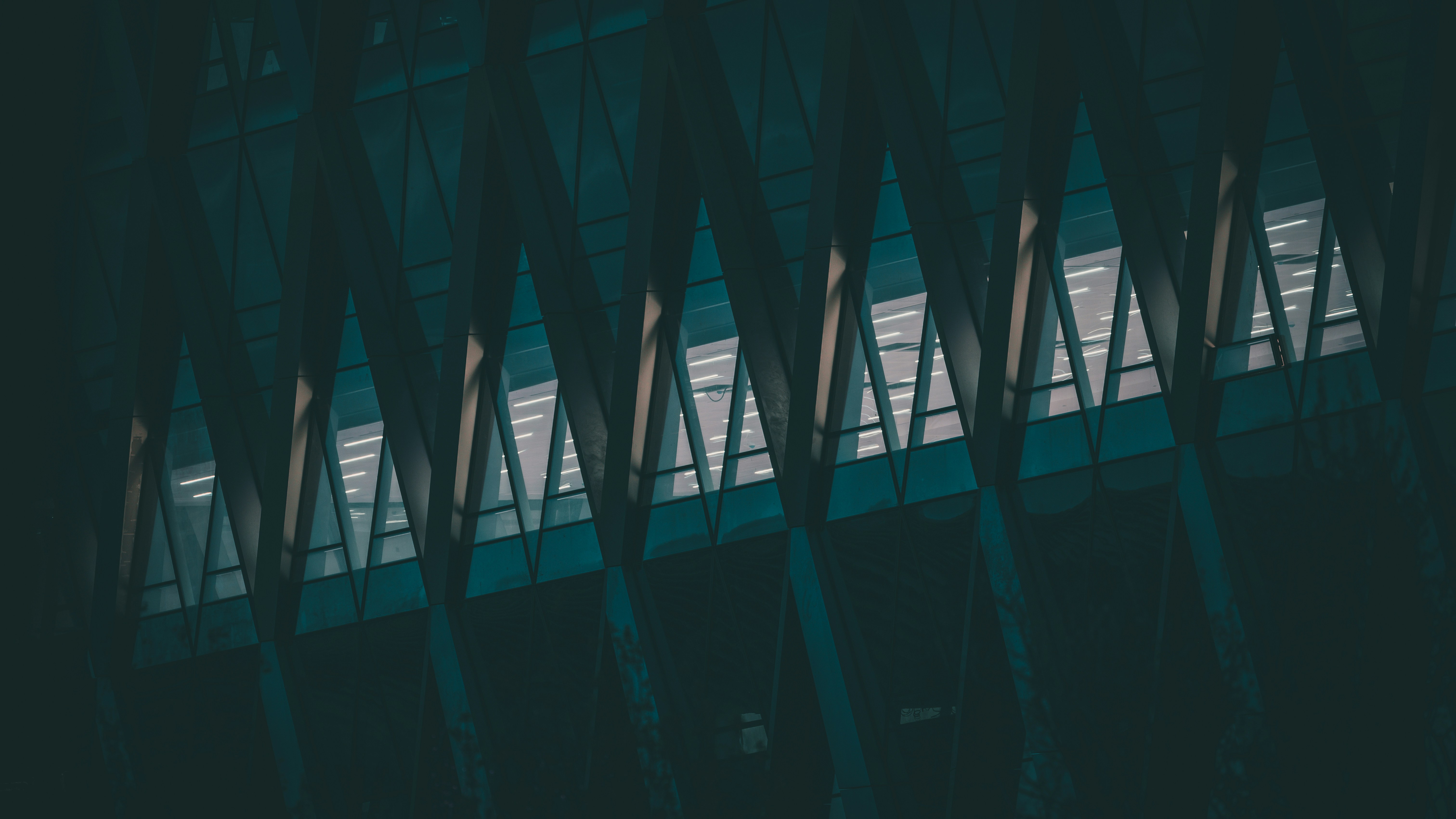Fachada moderna del edificio con ventanas triangulares al anochecer
