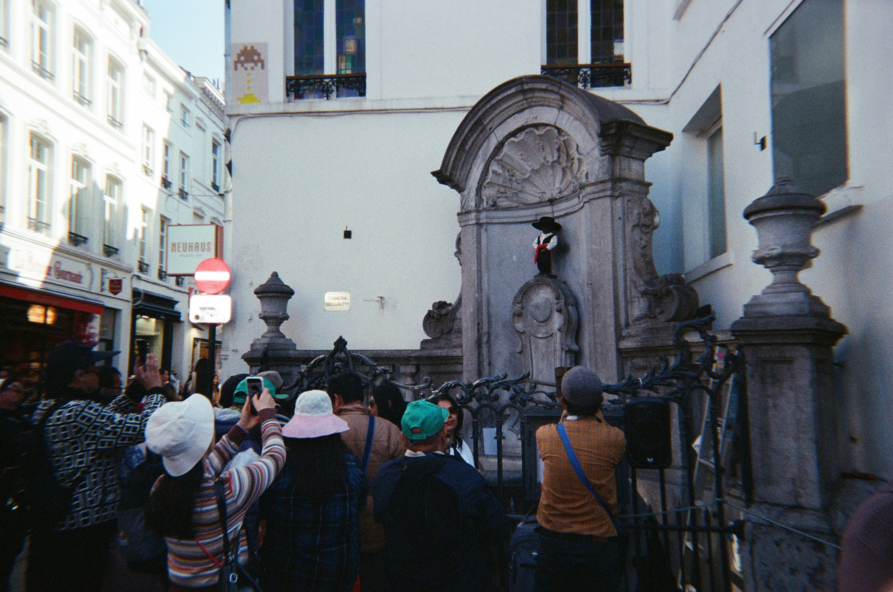 Tourists photograph manneken pis statue in brussels