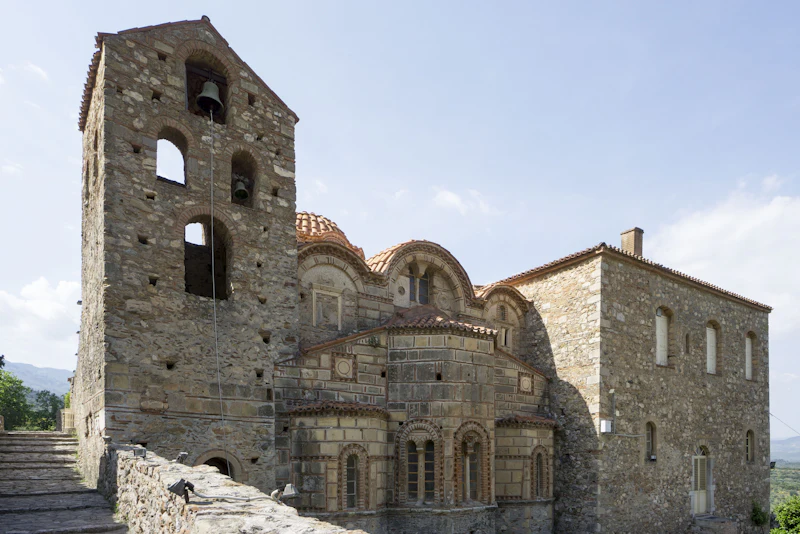 A Byzantine church with brick domes and a stone bell tower