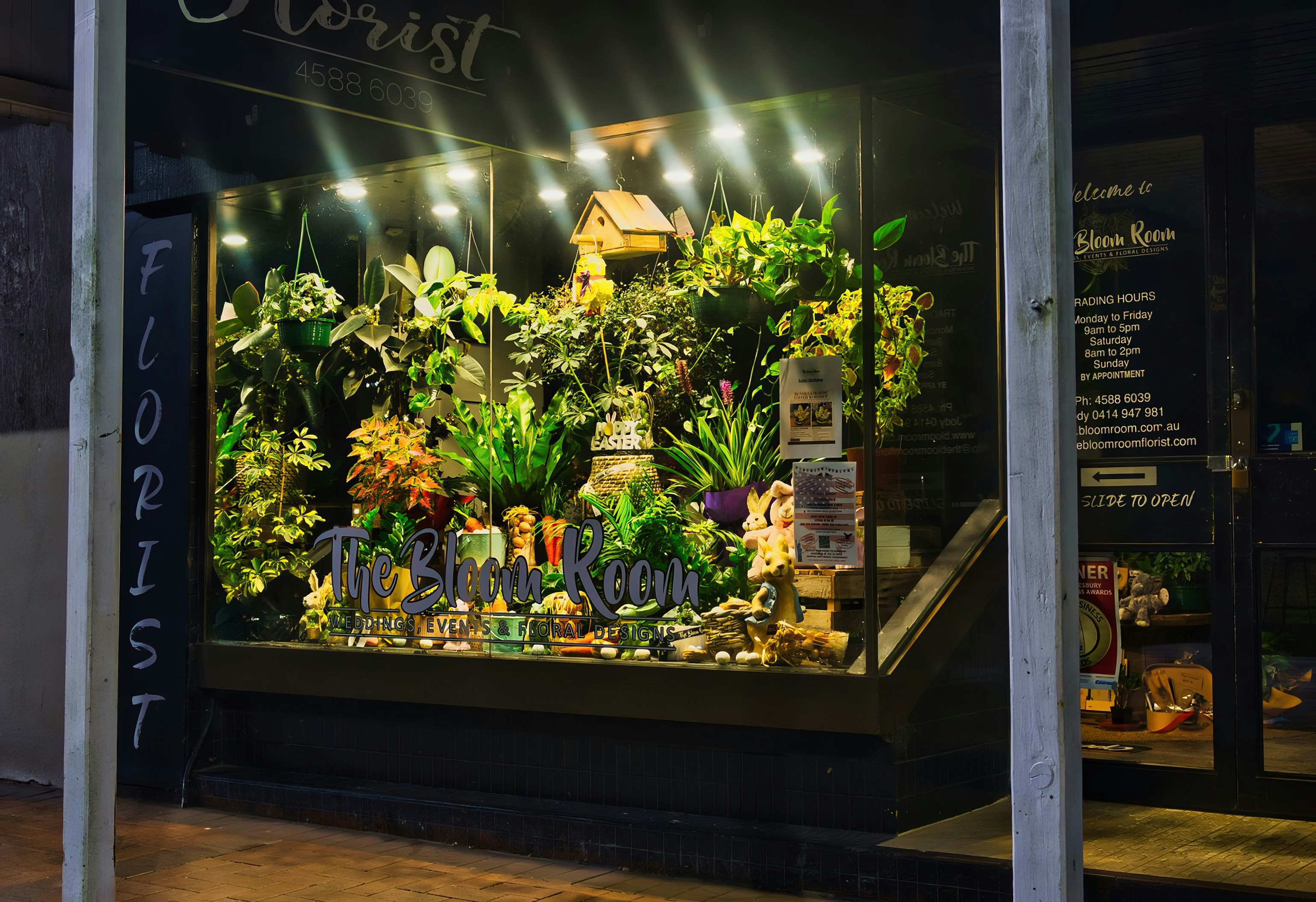 Florist shop window display lit up in the evening, Dagenham