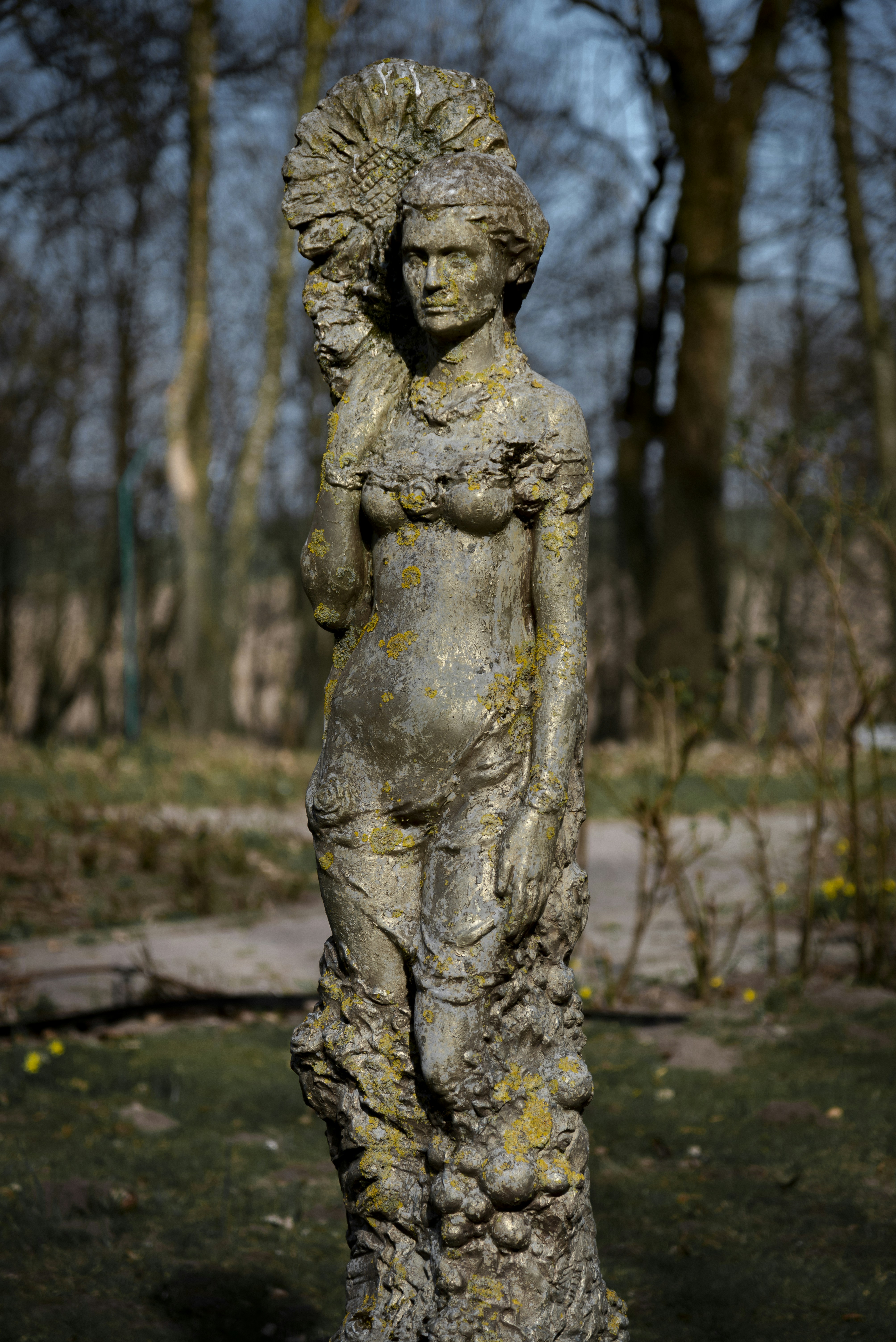 Steinstatue einer Frau, die eine große Blume hält